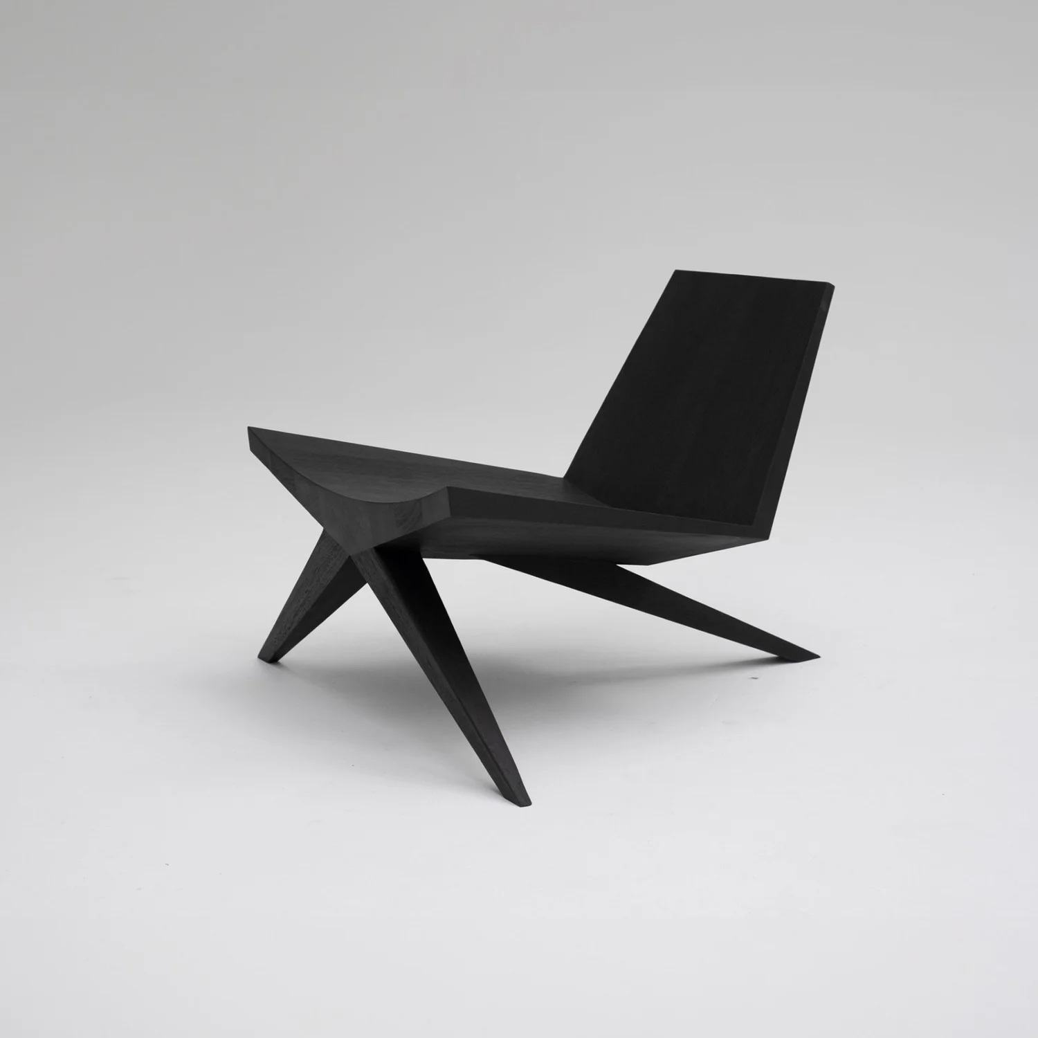 Alternate view of the angled backrest, seat and intersecting wooden legs of the V-Easy Chair by Arno Declercq.