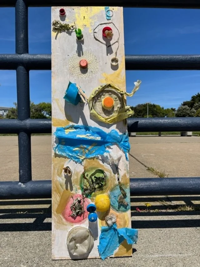 Tall mixed-media artwork created from collected litter and repurposed materials