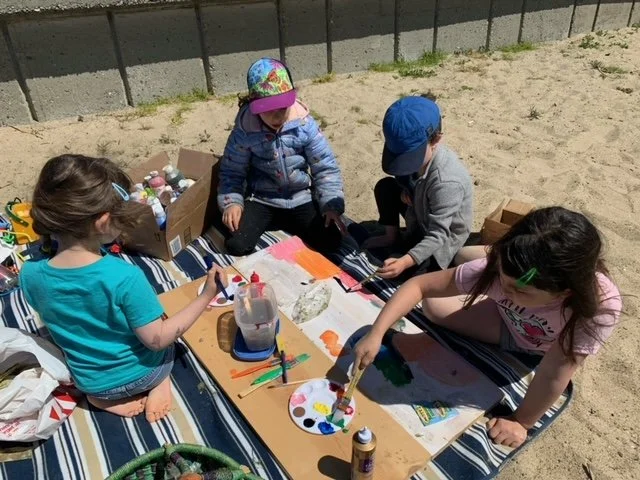 Children creating recycled art outdoors for an Earth Day family activity