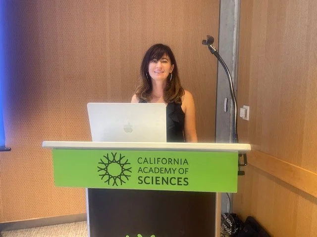 Ariella Cook-Shonkoff presenting at a California Academy of Sciences podium during The Internal Landscape workshop