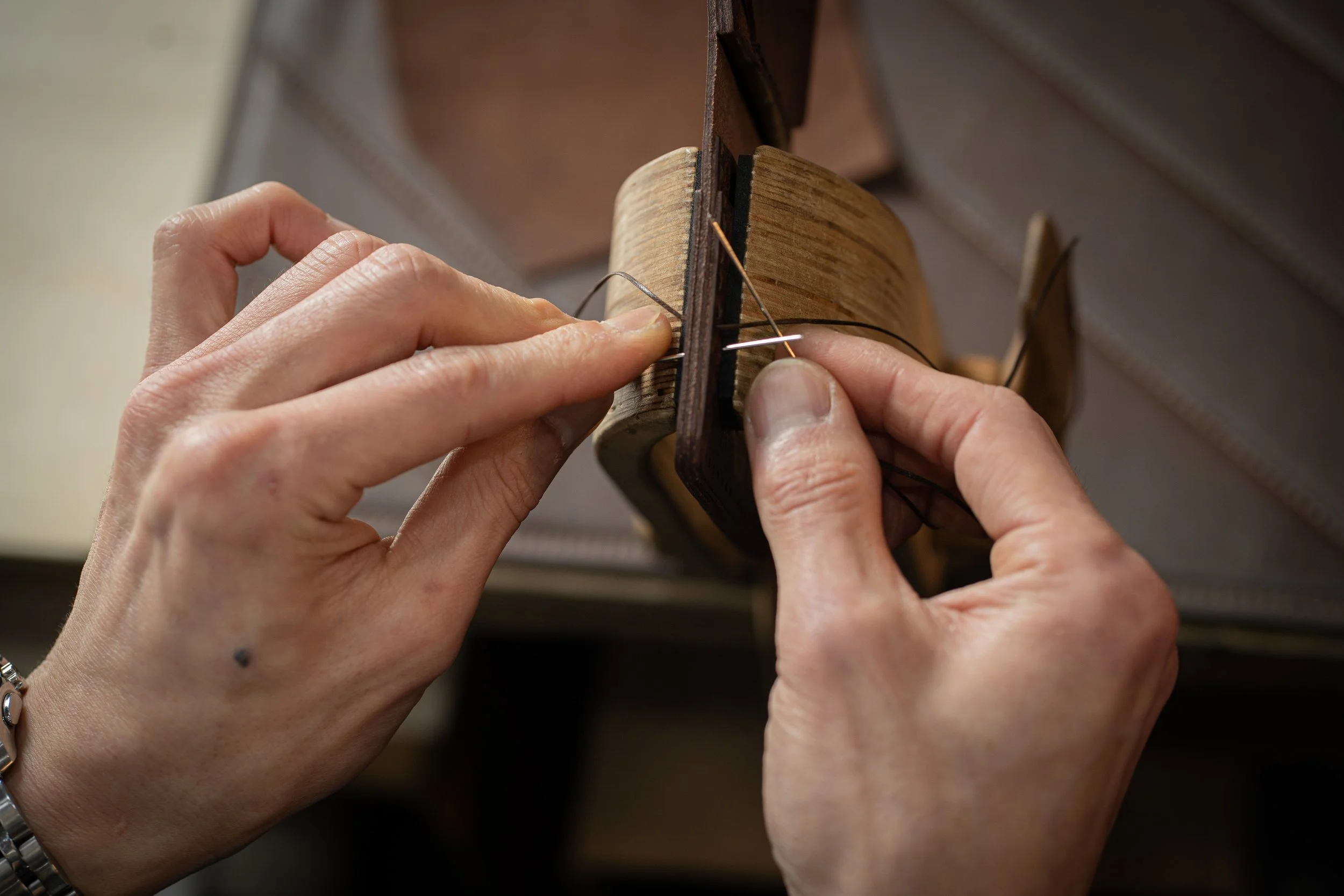 Joe hand stitching a leather piece in his atelier
