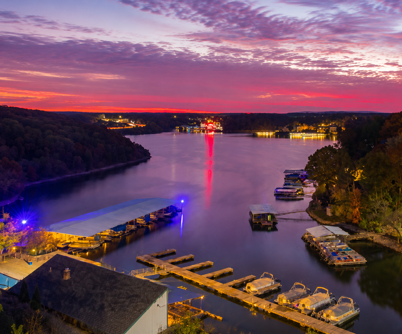 Sunset view overlooking Lake of the Ozarks with boats, docks, and colorful reflections on the water in Missouri.