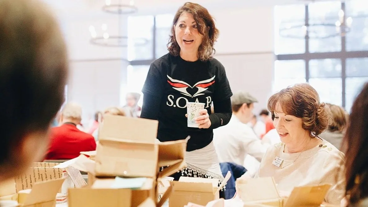 SOAP Project volunteer organizing outreach materials during a community soap labeling event to help prevent human trafficking.