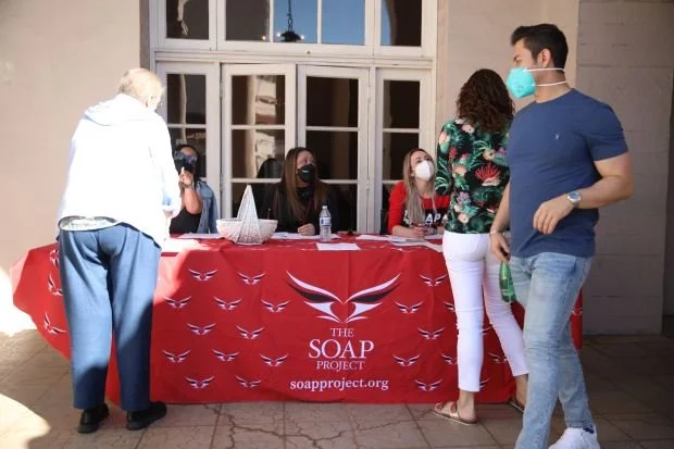 SOAP Project volunteers welcoming participants at an anti-human trafficking outreach event registration table.