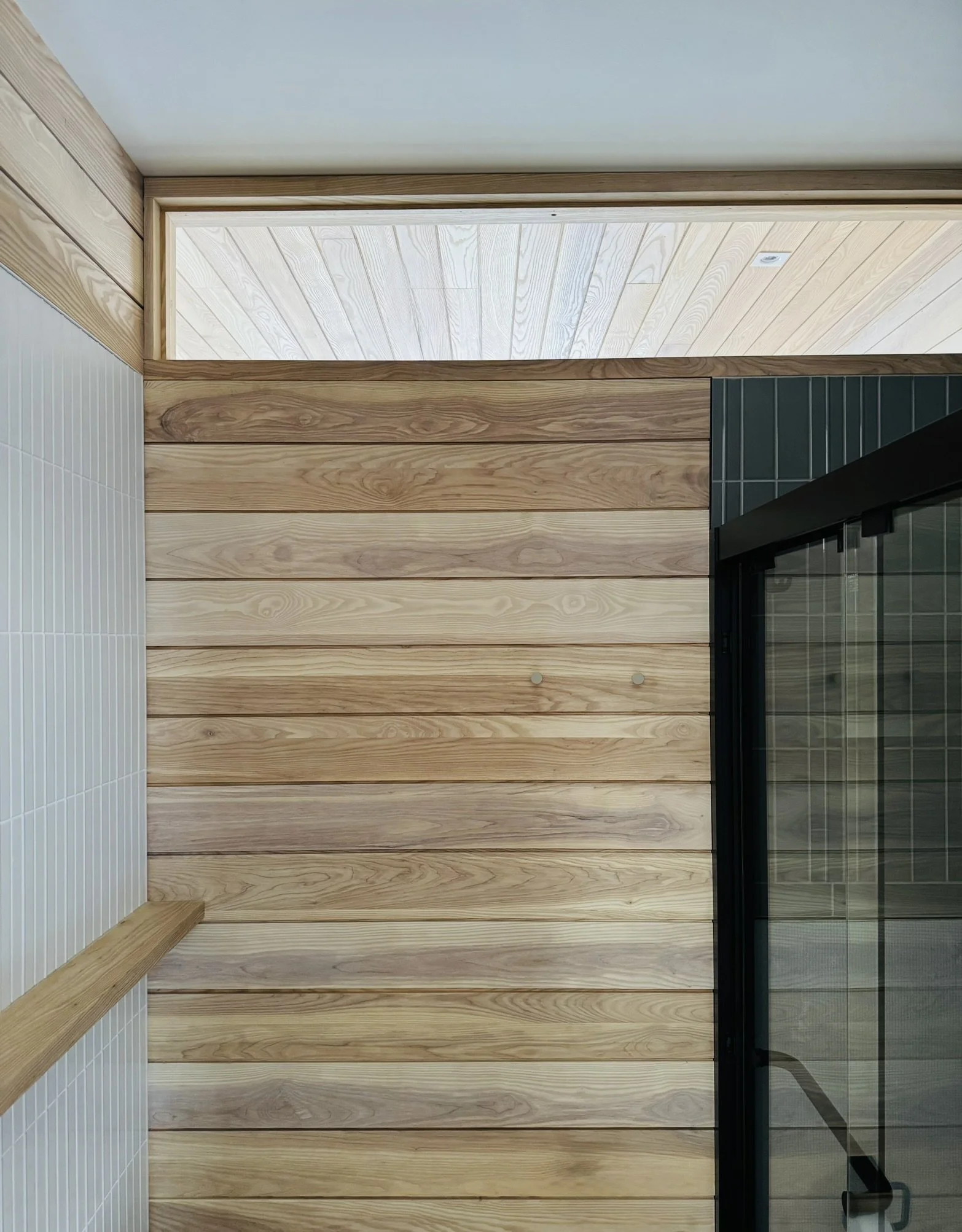 Accessible bathroom at Hinterhaus 41 by Elevin Design Studio featuring ash tongue and groove walls, white Scandinavian tile, and a transom window, modern residential interior, photo by Brad and Shawn Hernden