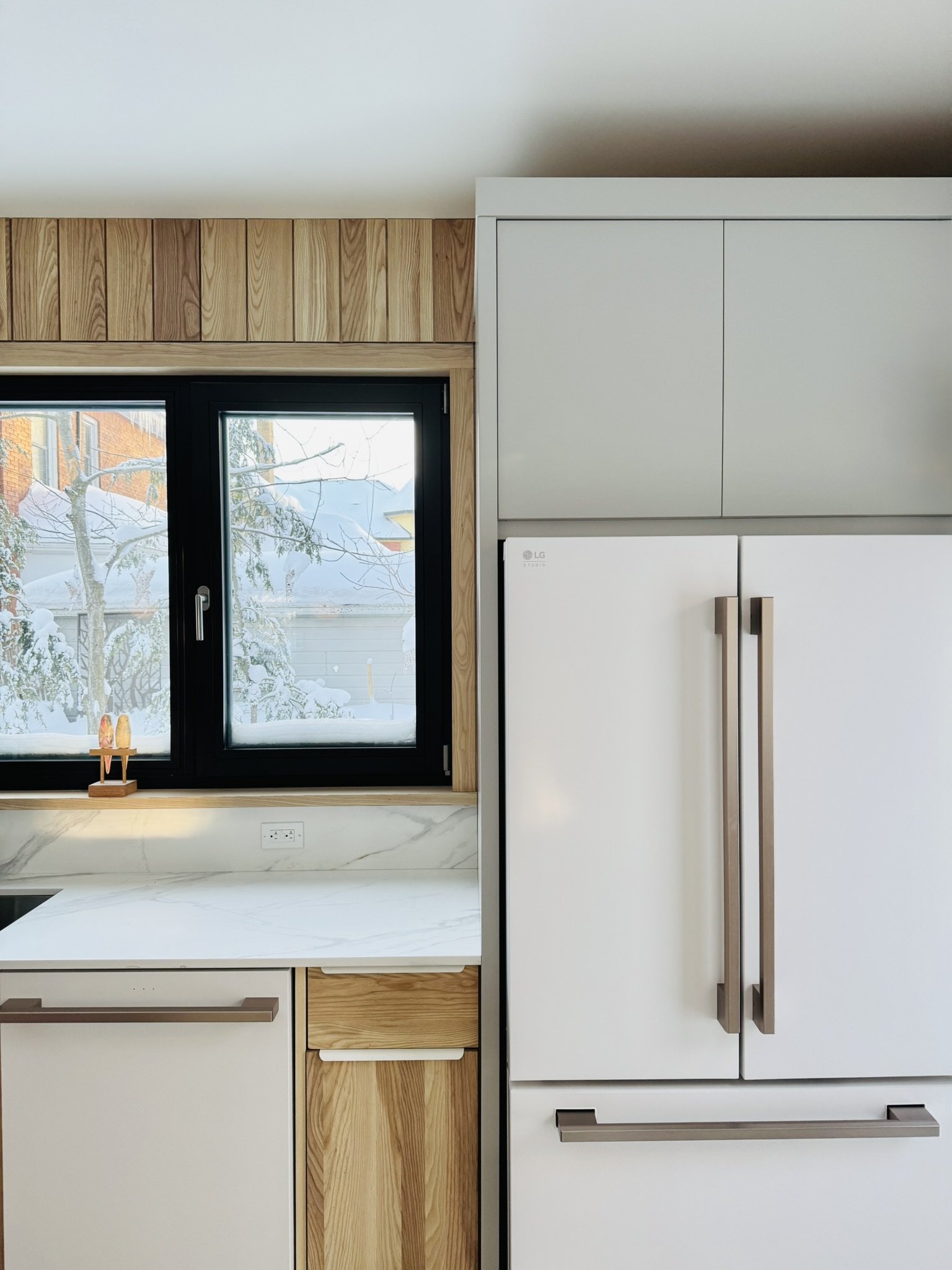 Modern ash wood kitchen at Hinterhaus 41 by Elevin Design Studio featuring a black architectural door, minimalist cabinetry, and contemporary lighting, photo by Brad and Shawn Hernden