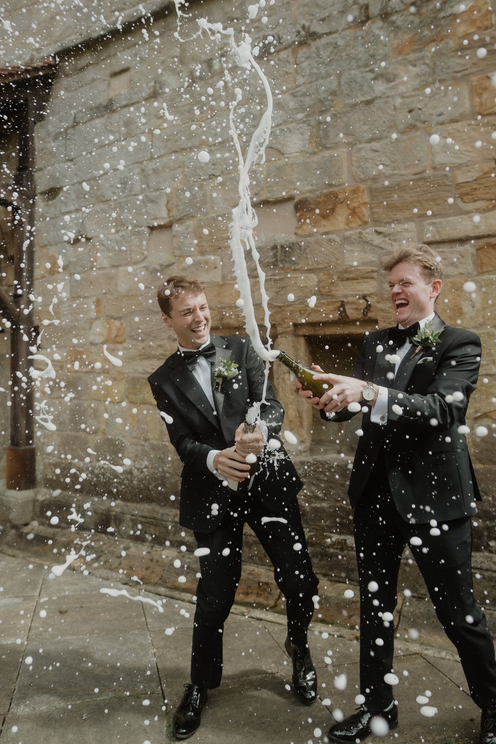 Gay couple celebrating their wedding with prosecco