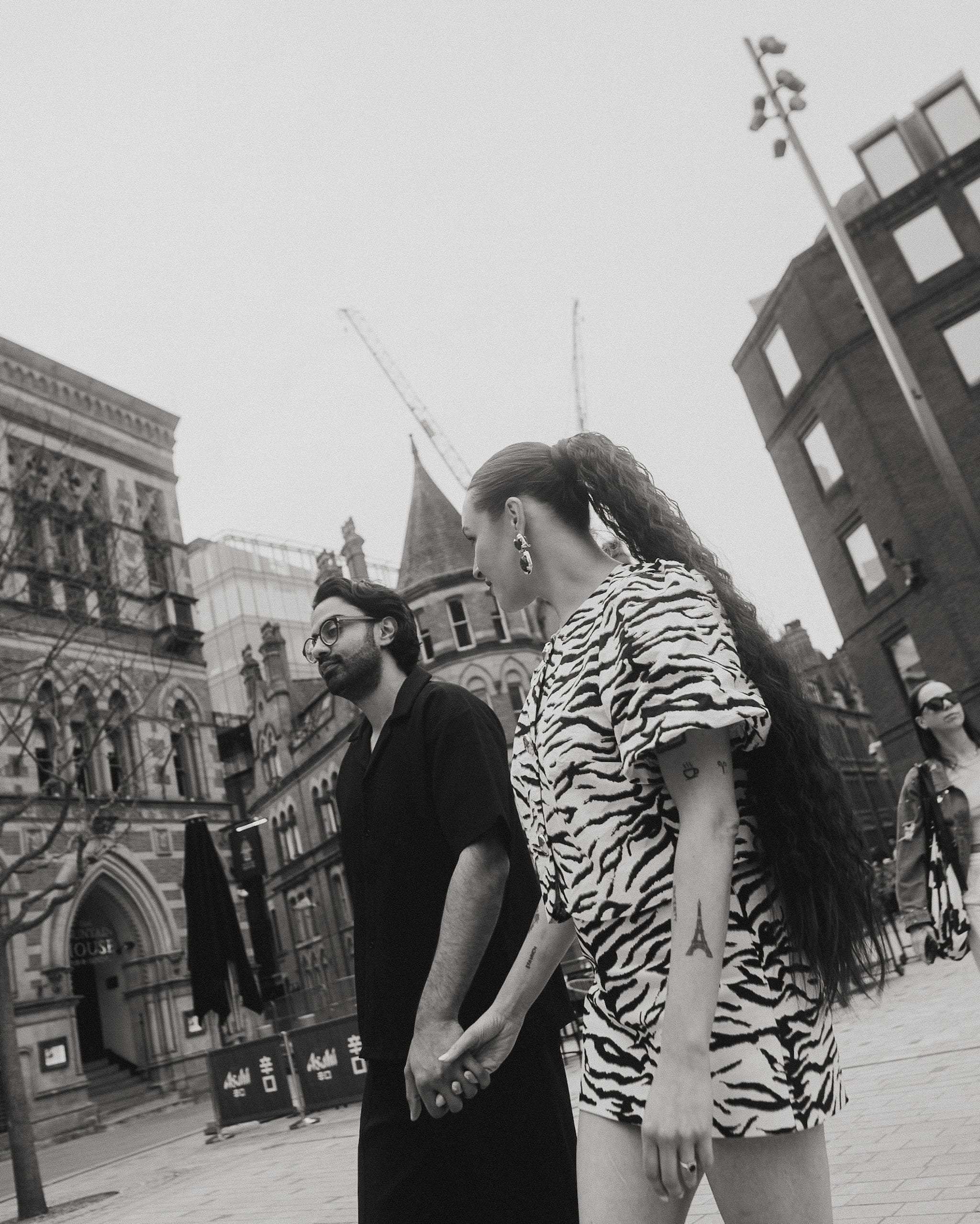 Couple walking through Manchester city centre during engagement session 
