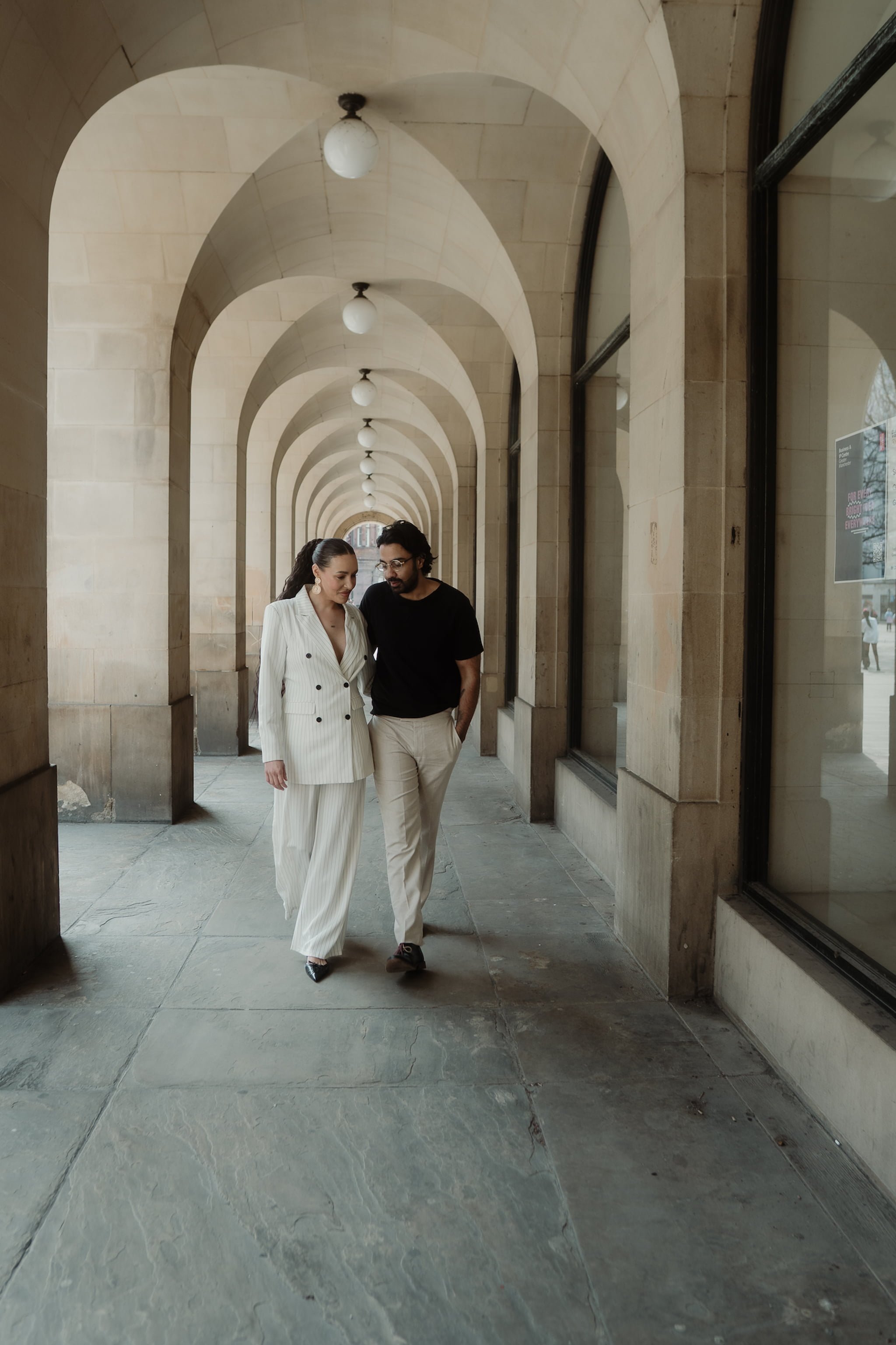 Cinematic engagement photo of couple walking through Manchester