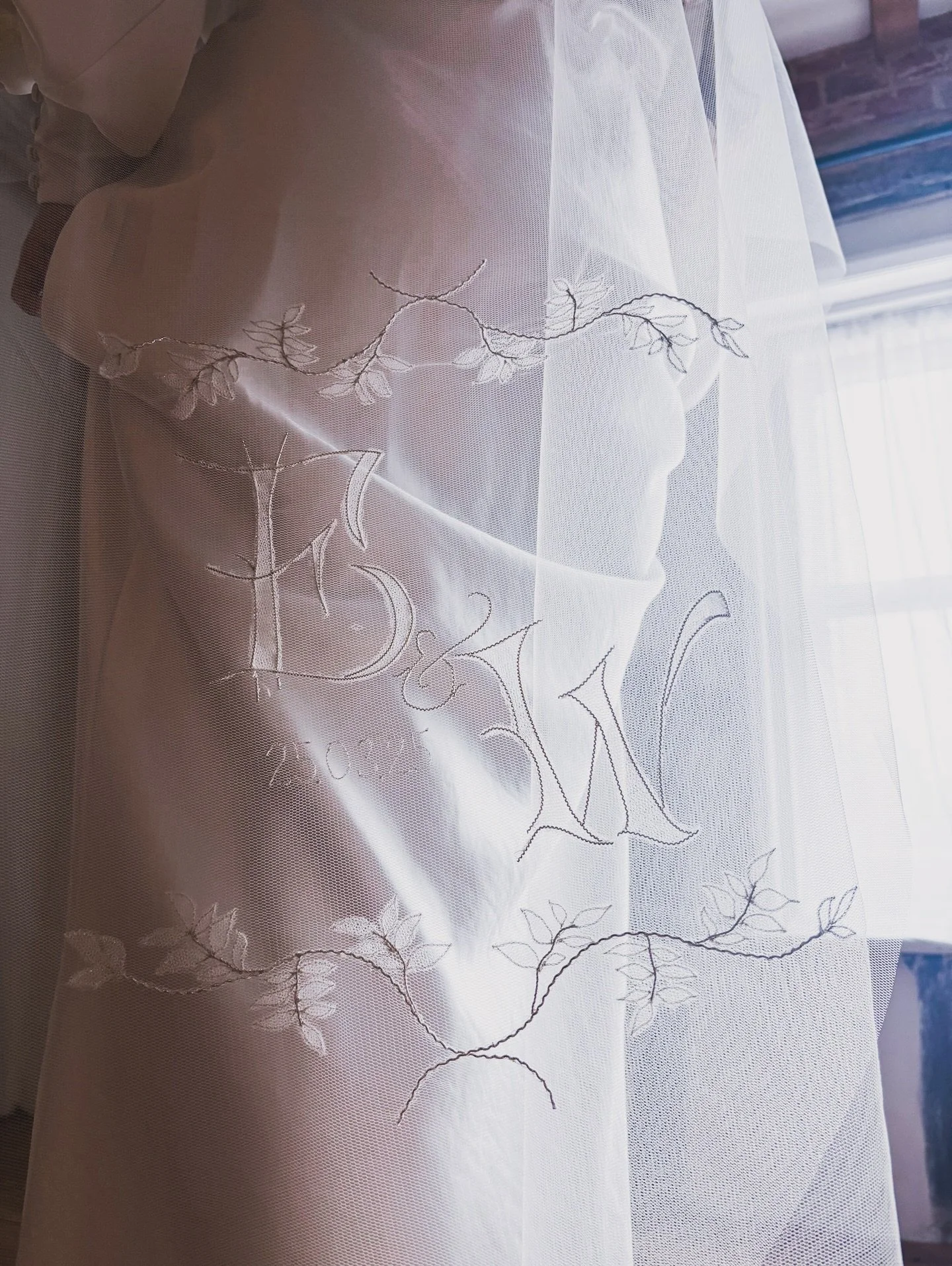 Something Silver -
Our customisable couture veil collection, this veil is hand embroidered with real silver. The wedding couples initials are framed with silver embroidered leaves and stems, nestled in the centre with the date. 
Edit your initials in