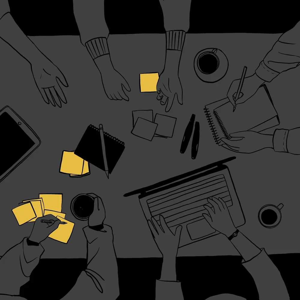 hands+around+table+one+grey+few+yellow.webp