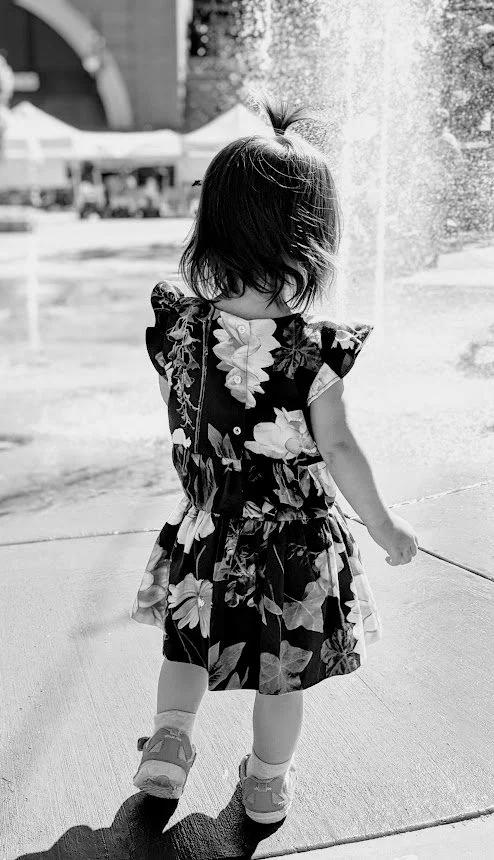 Toddler wearing floral ruffle dress back profile