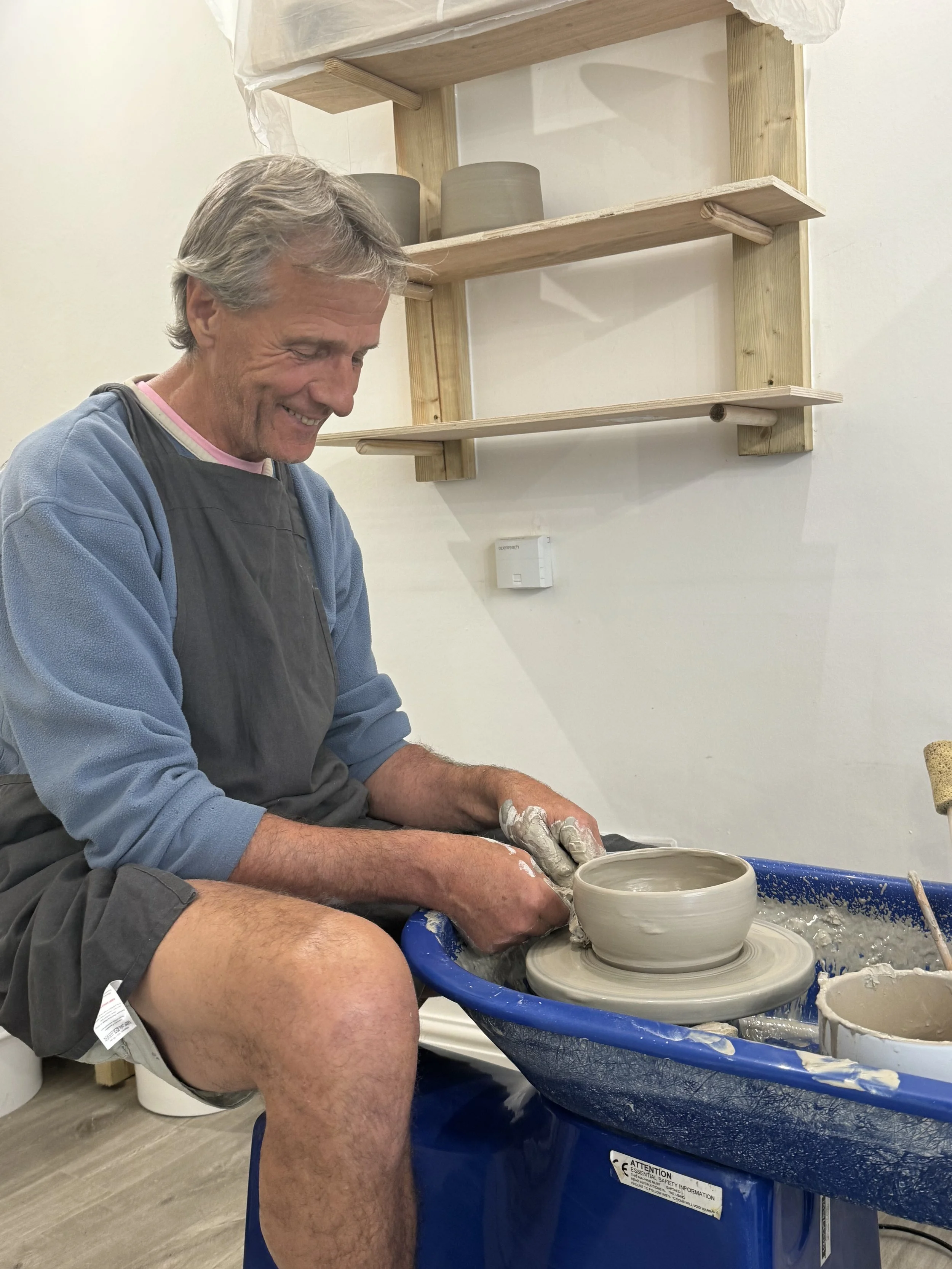 Man throwing on a pottery wheel Two participants shaping clay on pottery wheels during a beginners’ class at Clod Pots, Exmouth.