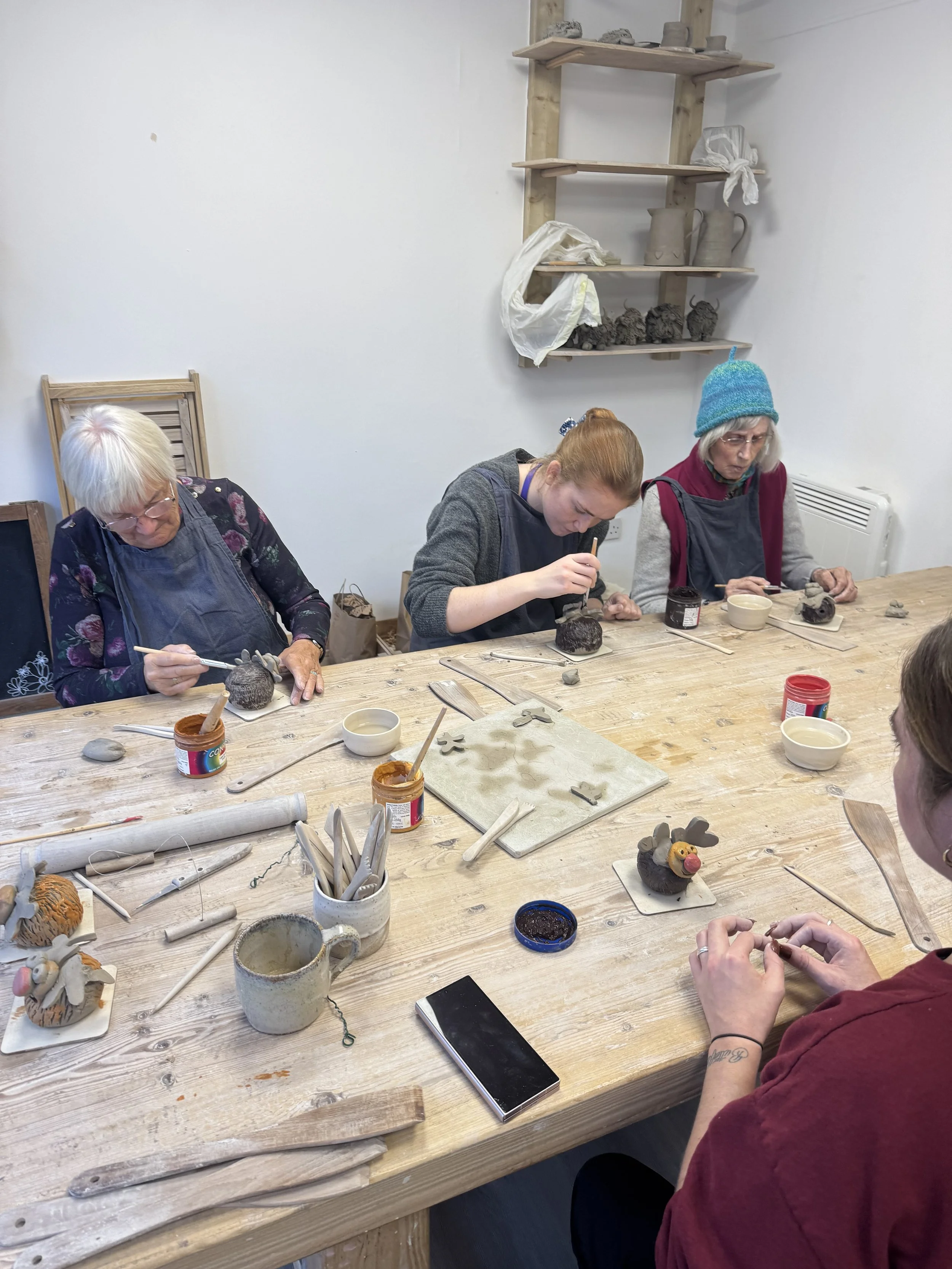 Participants enjoying a creative pottery activity at Potty and Clod Exmouth