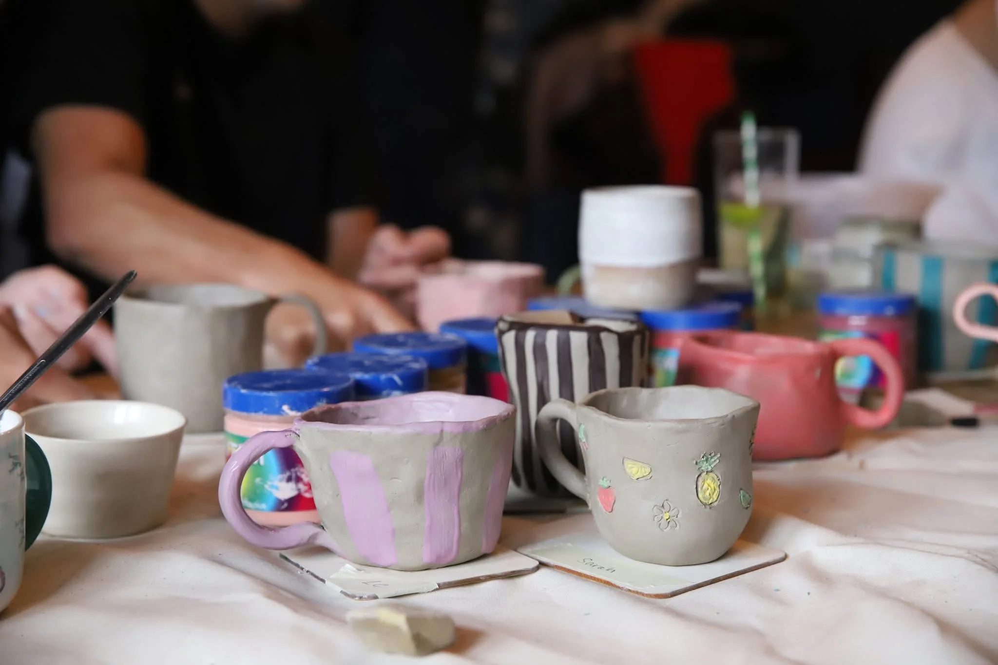 Finished clay mugs and handbuilt pieces from a charity workshop at the pub