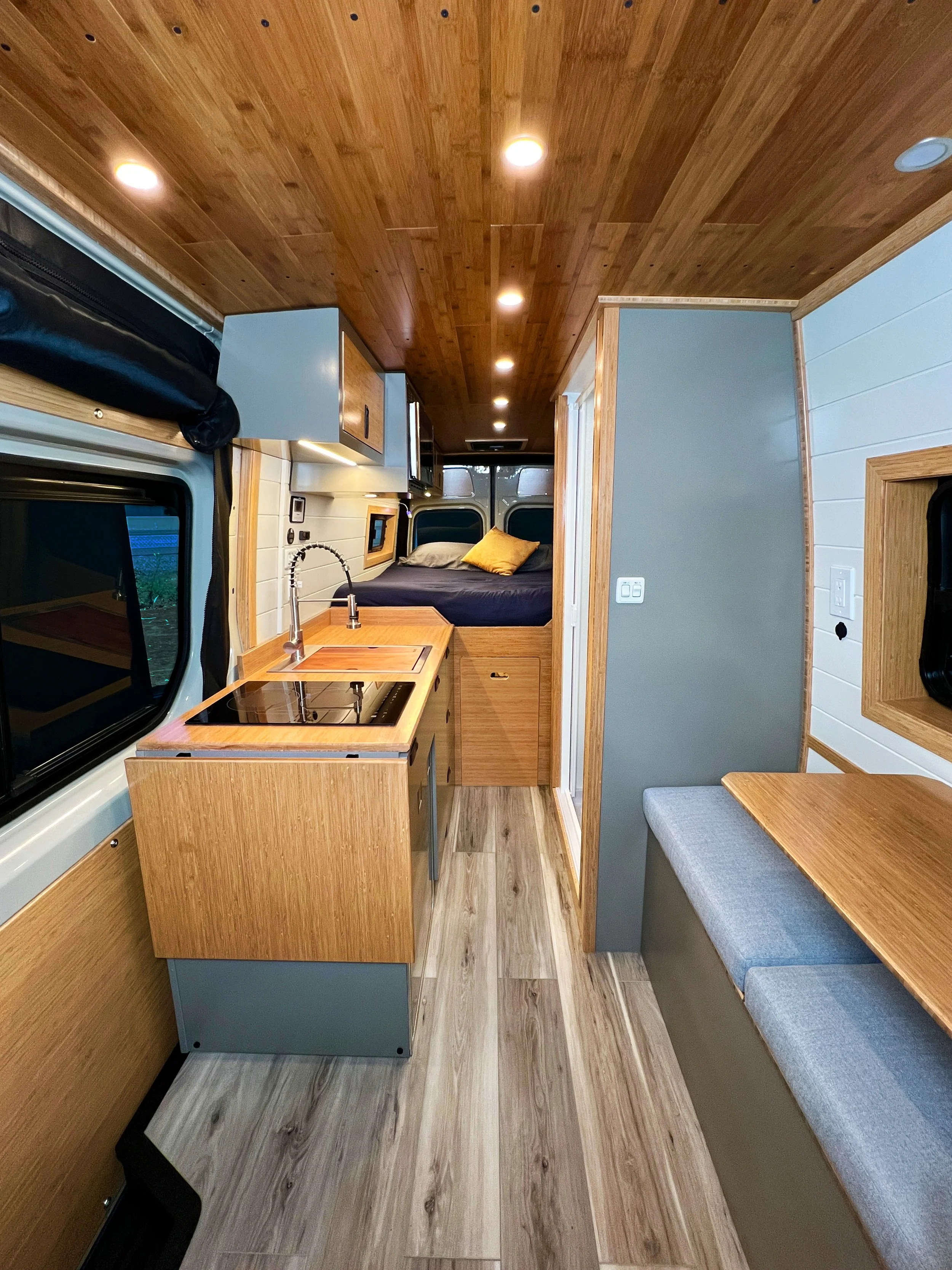 The Cascade Rental Van is a roomy floorplan despite the indoor shower, featuring a kitchen, long bench, near king bed, and microwave