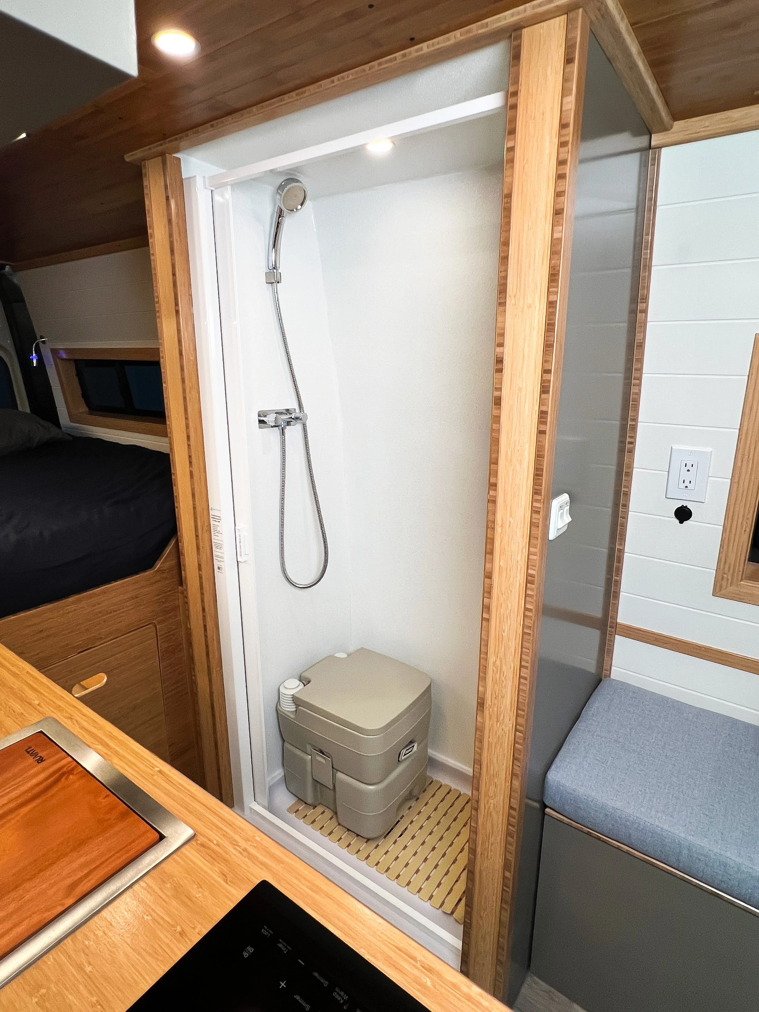 A removable chemical toilet is housed in the shower