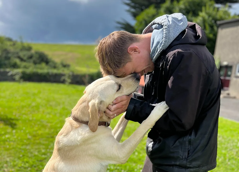 Gerard with a Labrador on a hillside