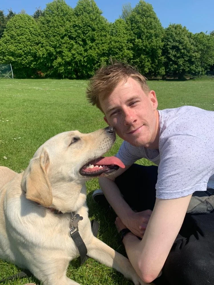Relaxing with a Labrador on the grass