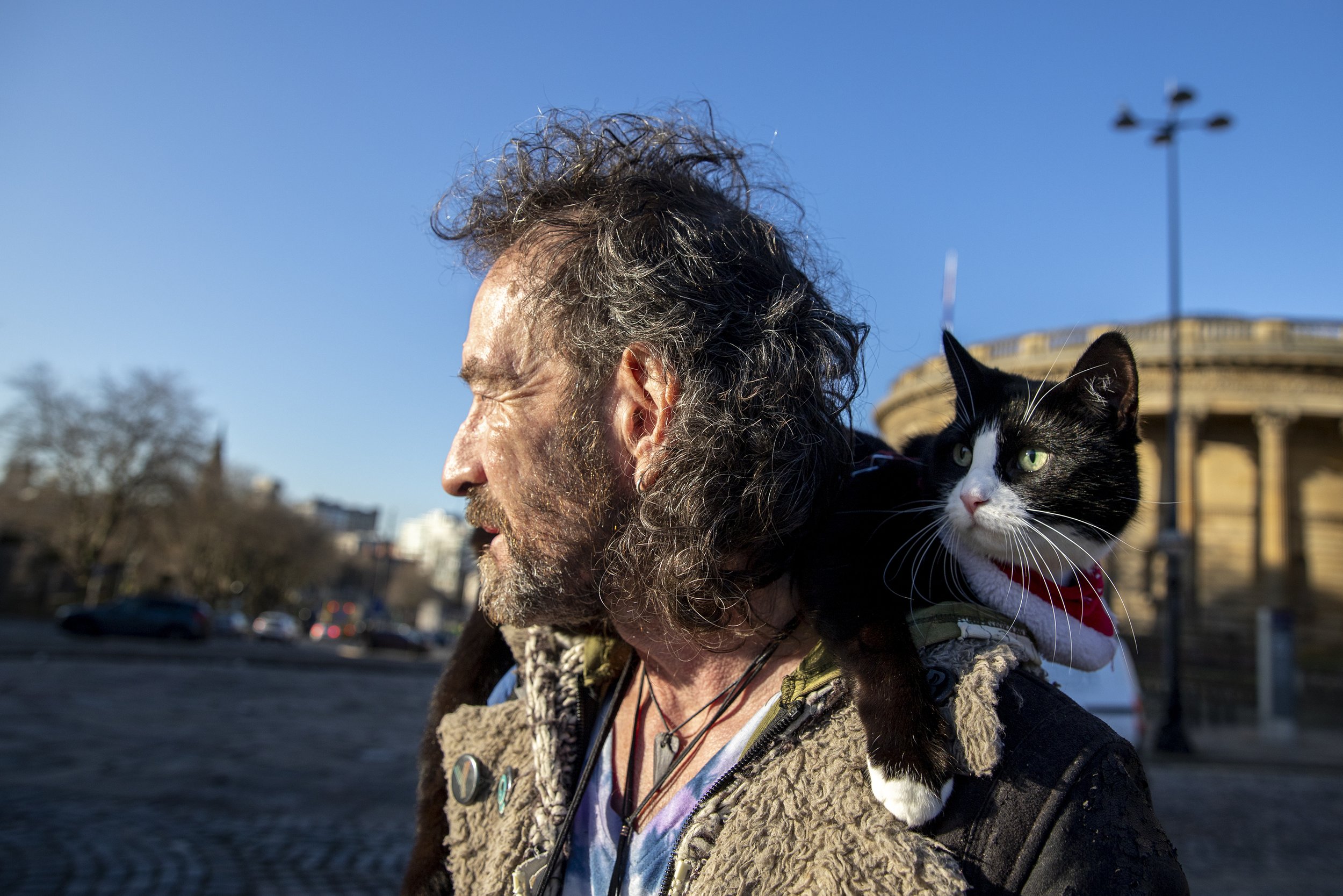 A man and his cat attend a protest outside St George's Hall in Liverpool, England. December 2019.