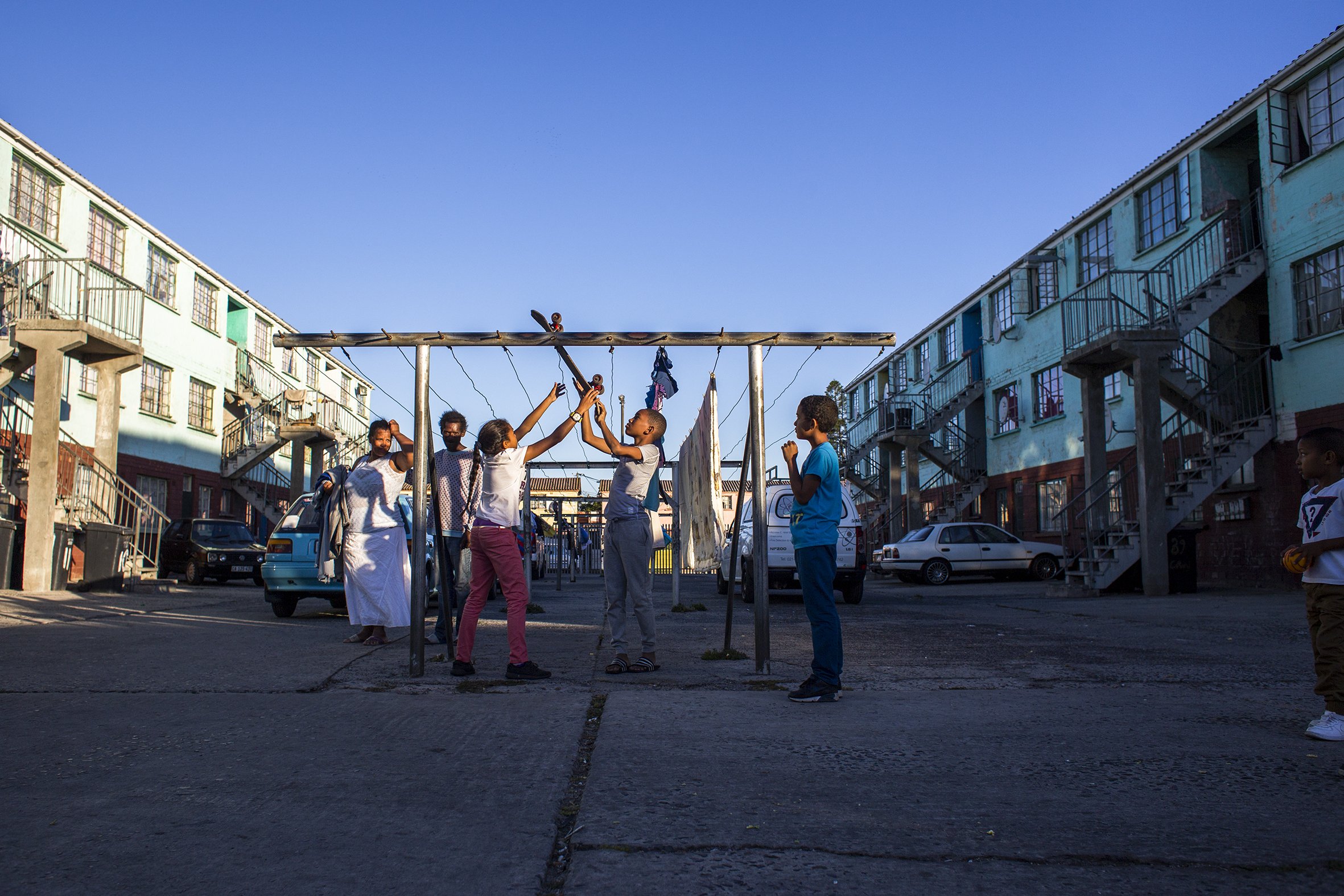 Children play close to a washing line in Parkwood, a suburb on the Cape Flats. April 2017.