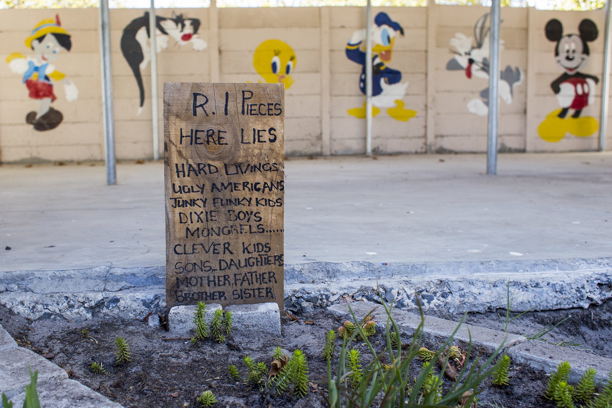 A wooden gravestone listing the names of numerous Cape Flats gangs in one of the gardens at the Ottery Youth Care Centre. March 2017.