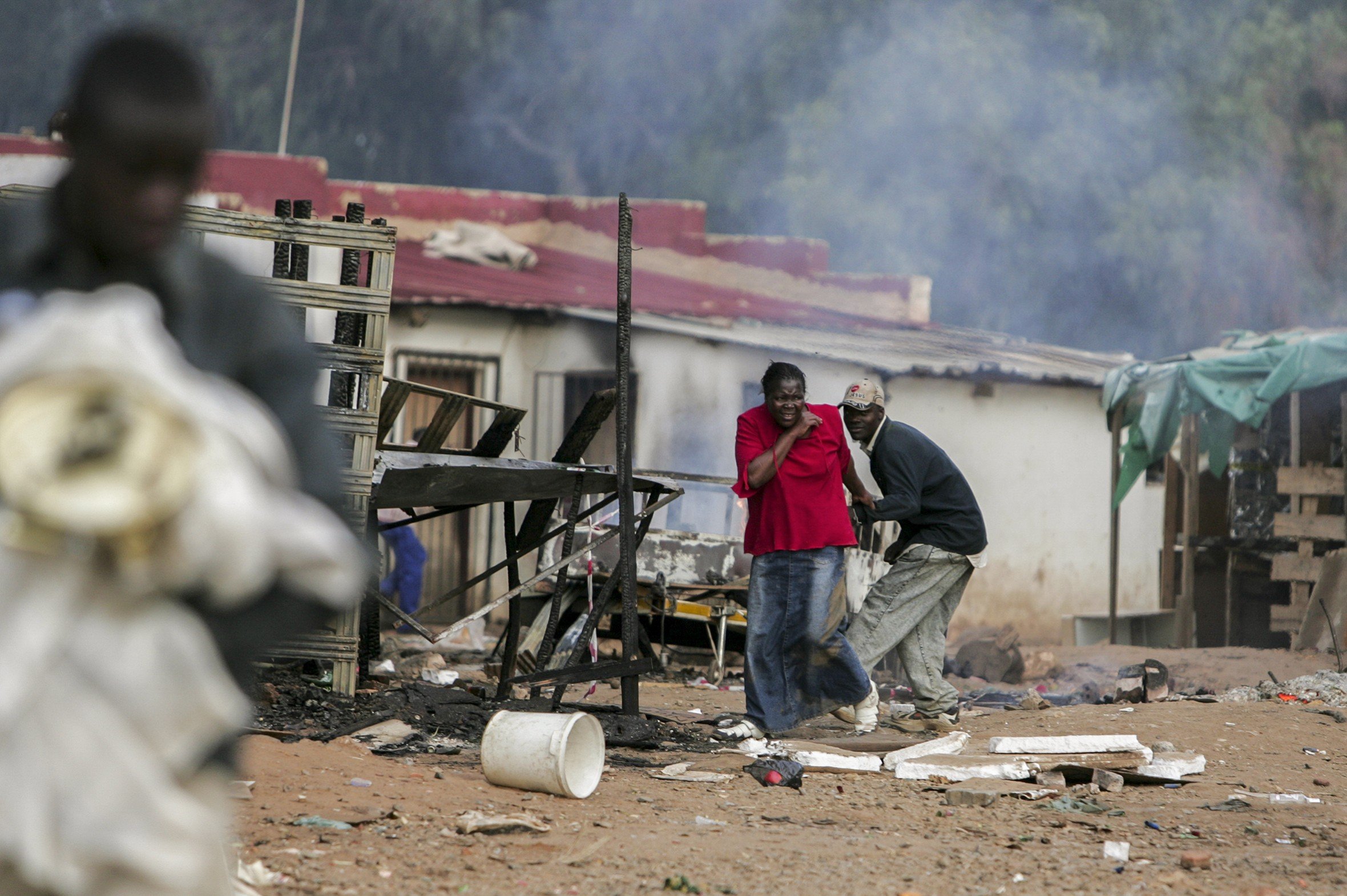 Trying to escape, foreigners dodge stones and rubber bullets during clashes between police, foreigners and local residents. Makausi, east of Johannesburg, South Africa.