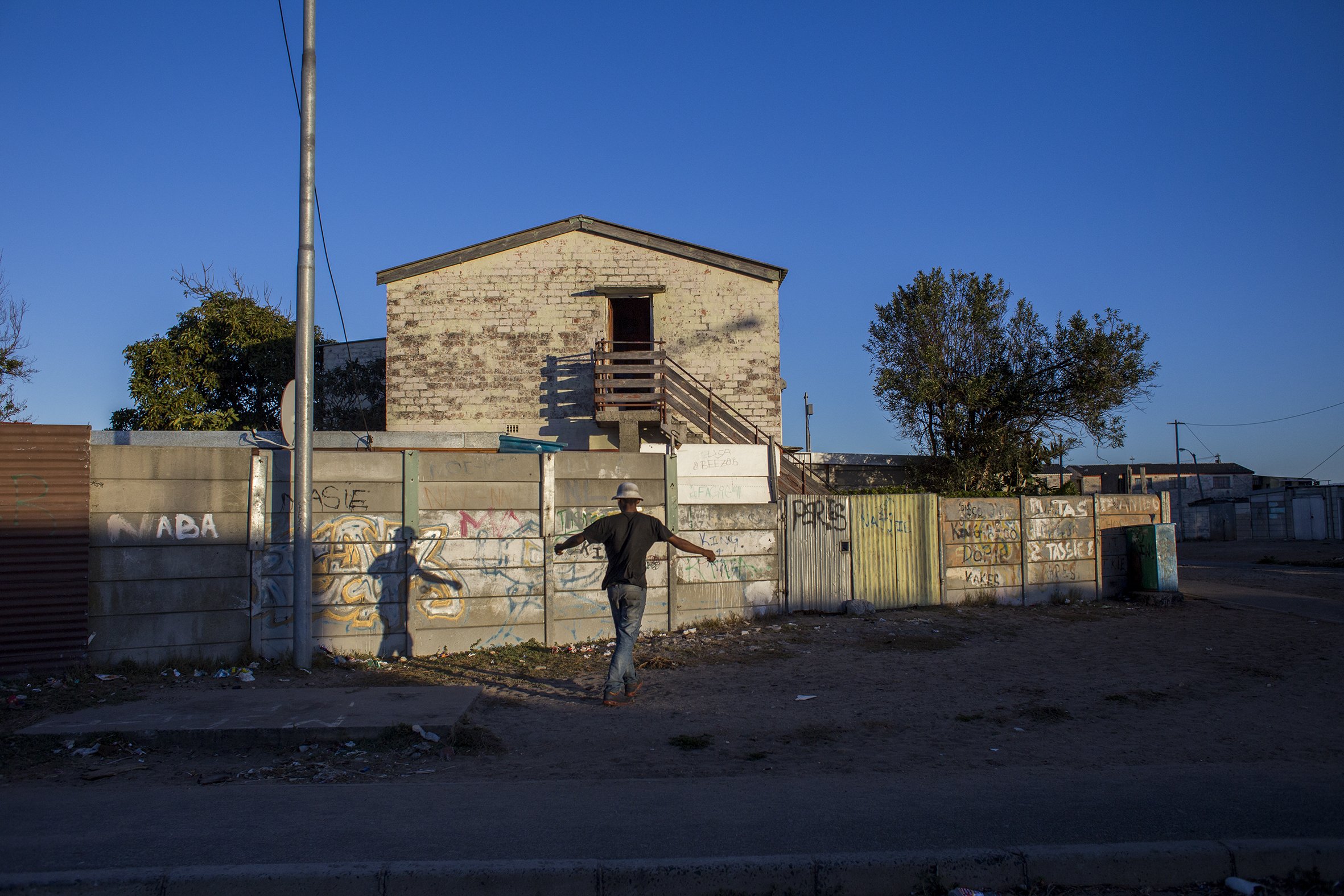 A man walks down a street in Parkwood, a suburb on the Cape Flats. April 2017.