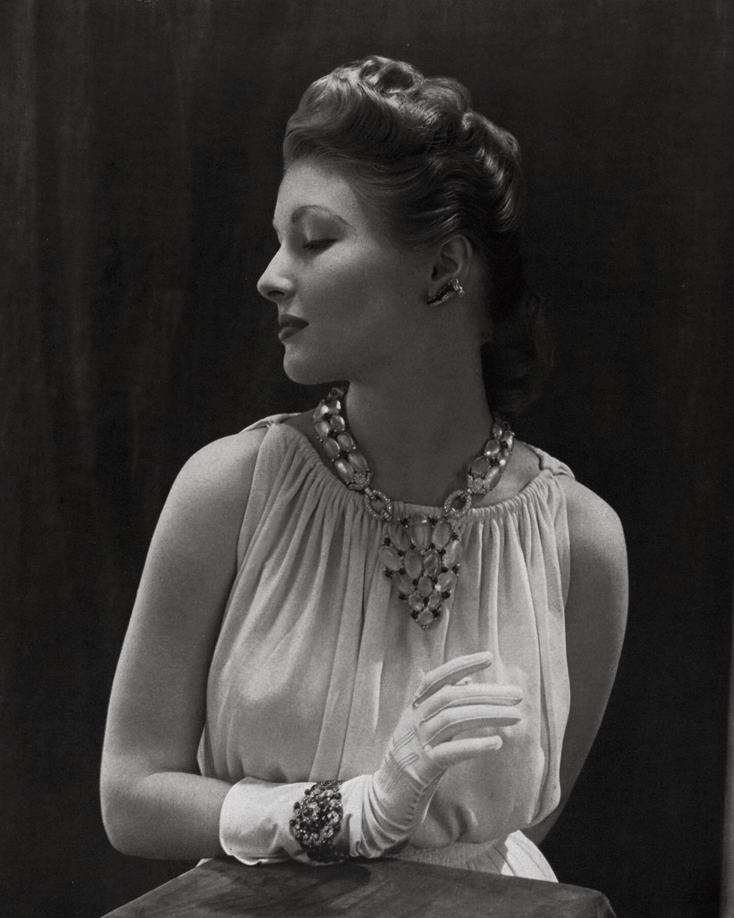Model wearing a luminous Flato necklace of moonstone, ruby, diamond, &amp; platinum paired with Flato earclips and bracelet of diamond, ruby, &amp; platinum. 

Photograph by Edward Steichen. Vogue, October 1939.