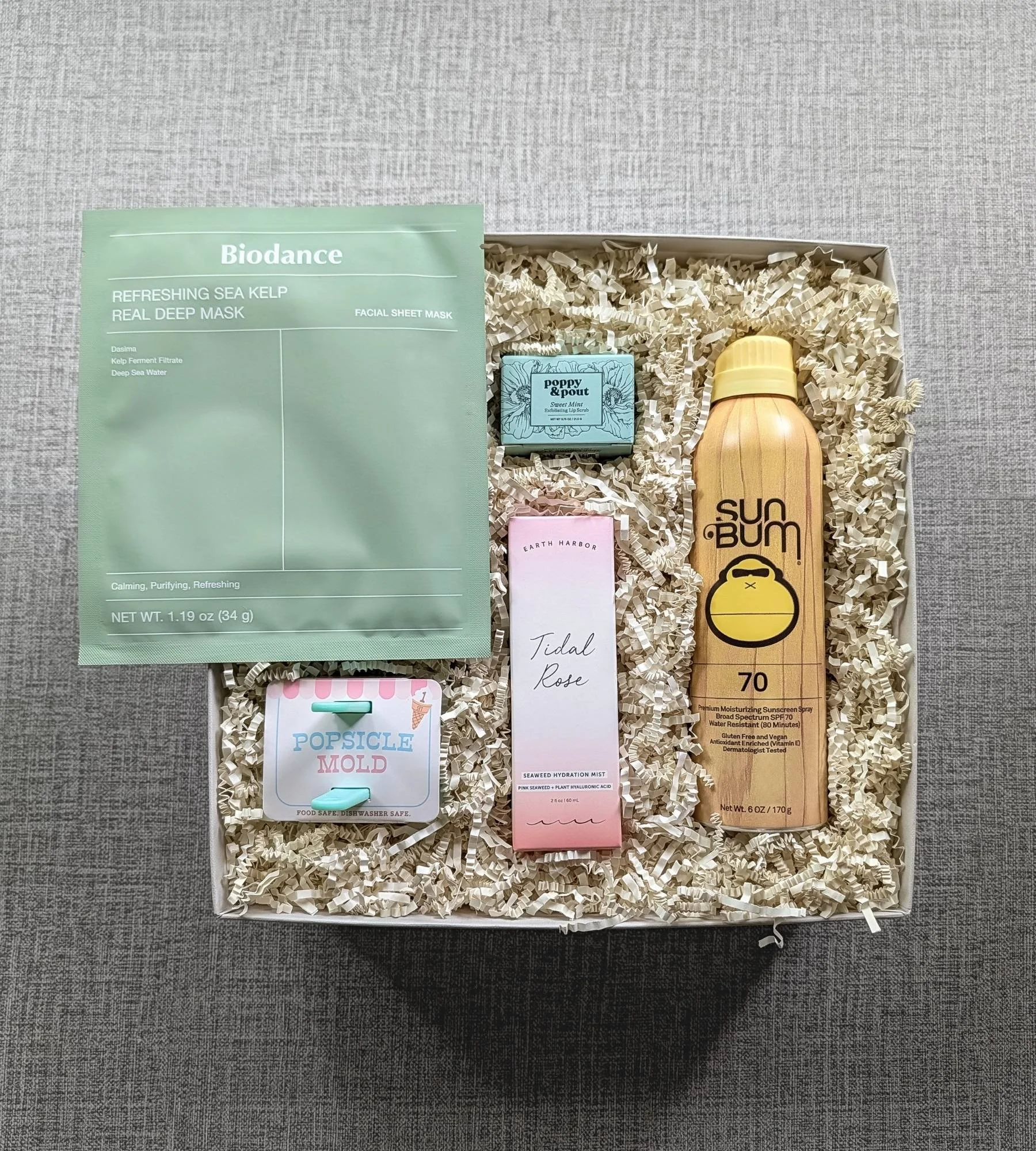 Curated poolside gift box featuring Sunbum 70 sunscreen, sweet mint lip scrub, hydrating facial spray, and a cute popsicle mold.
