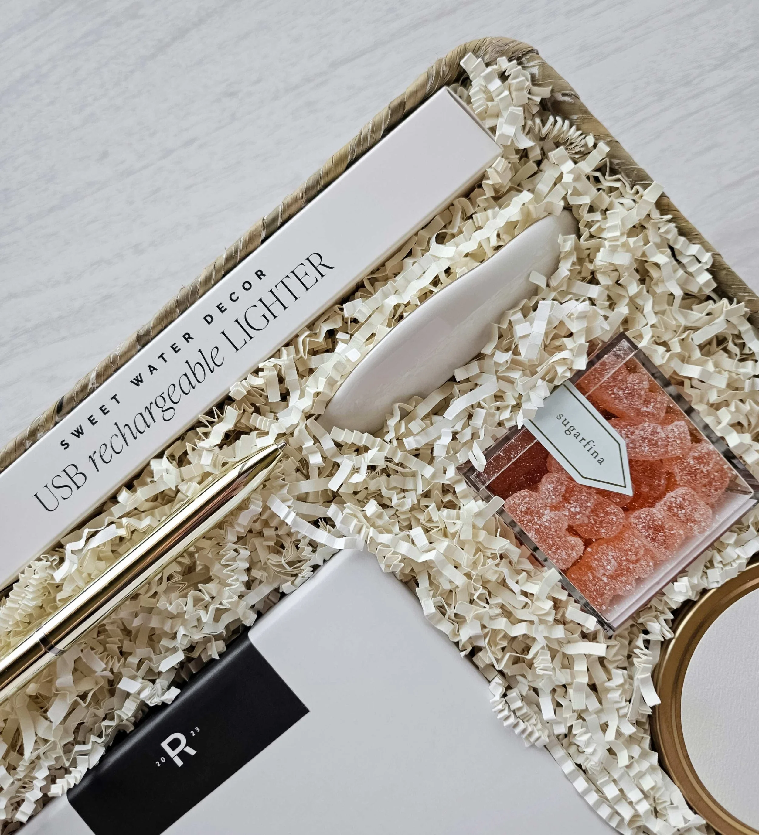 The Vow wedding gift basket featuring a USB lighter, champagne gummies, shower steamers, ring dish, and candle.