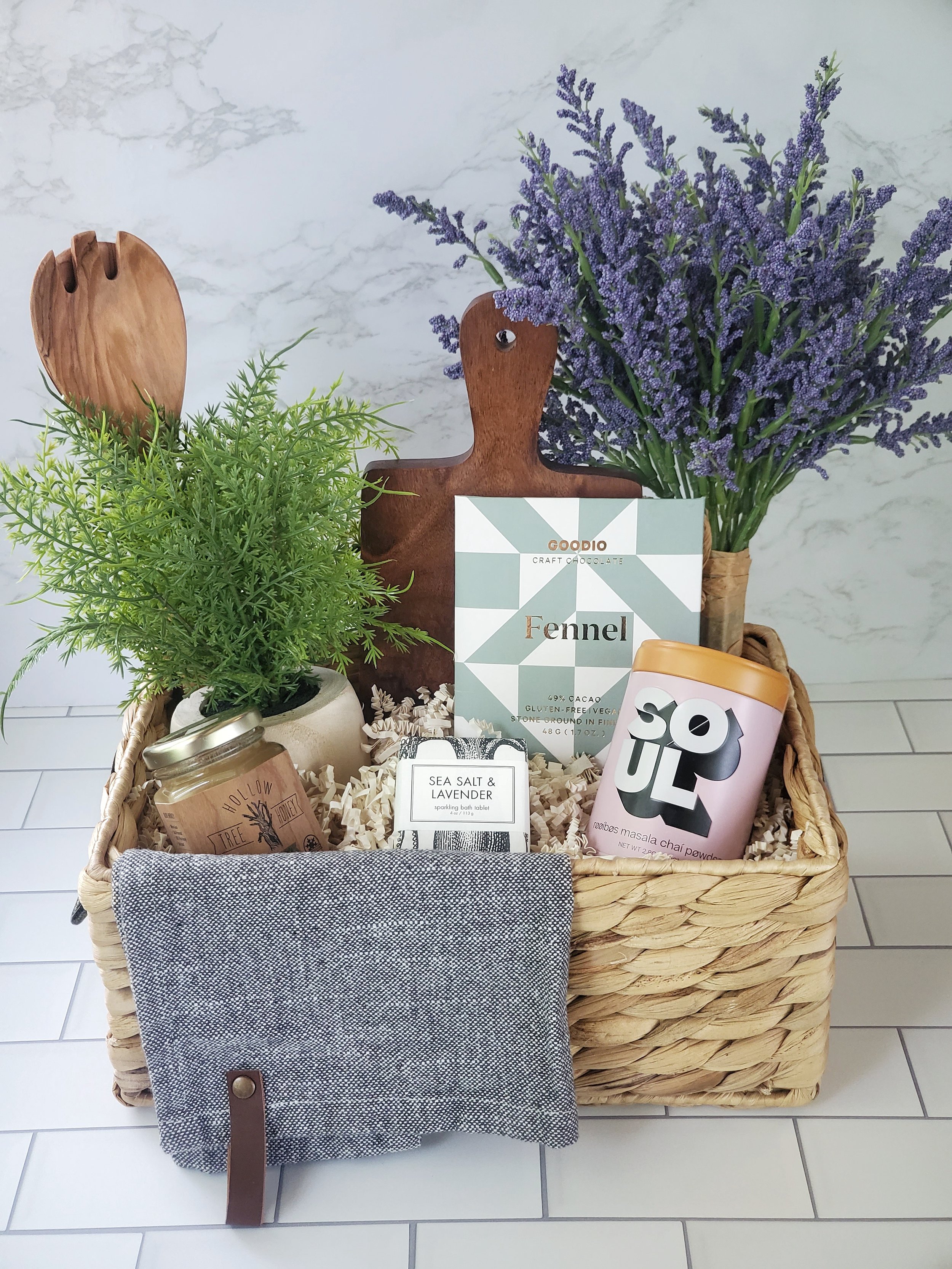 gift basket with chai tea, fennel chocolate, small batch honey, cheese board, and bath tablet