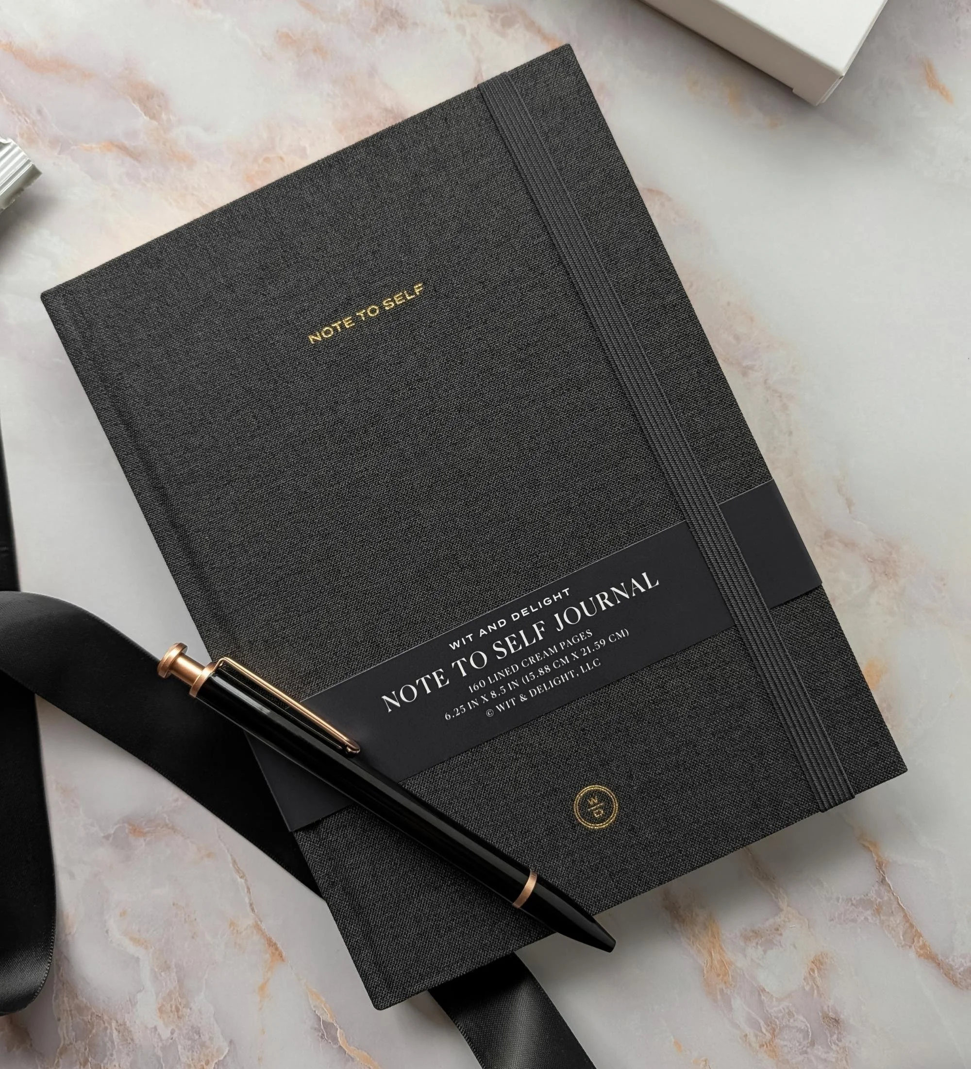 Sophisticated corporate appreciation gift set with black notebook, black pen, and curated modern accessories.
