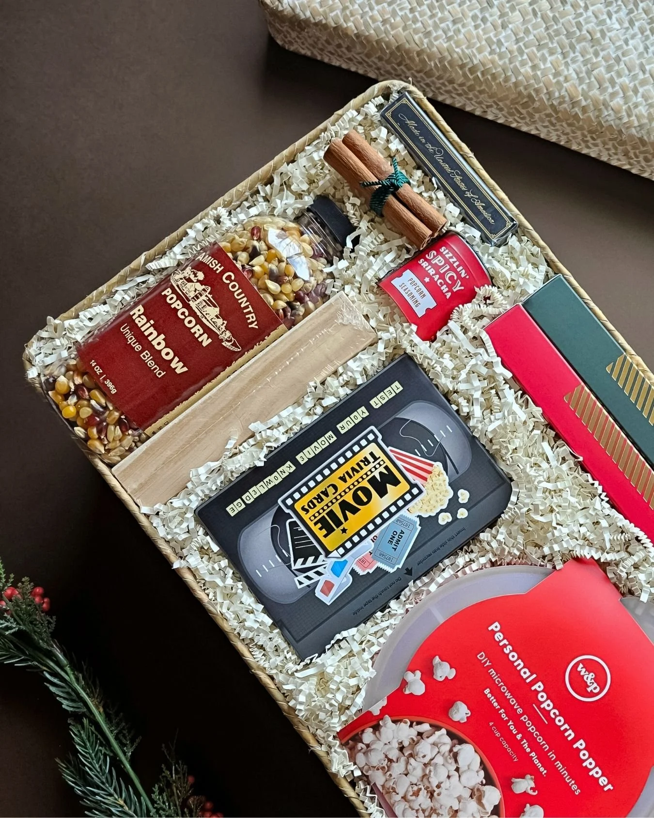 Cozy holiday gift basket with hot cocoa, trivia, games, and gourmet treats for family gatherings or client appreciation.