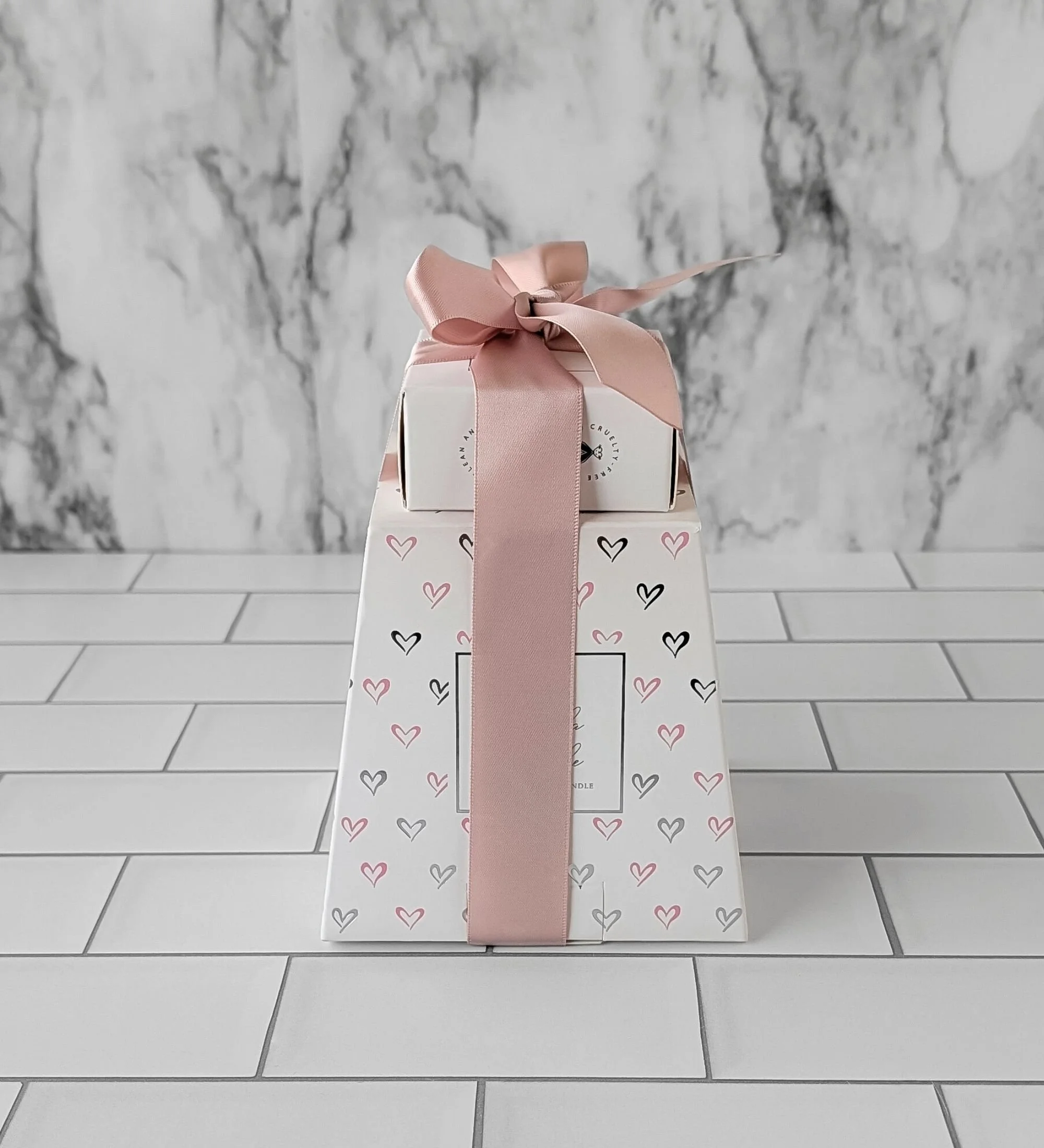Modern birthday spa gift featuring a boxed candle and steamer wrapped in soft blush ribbon.
