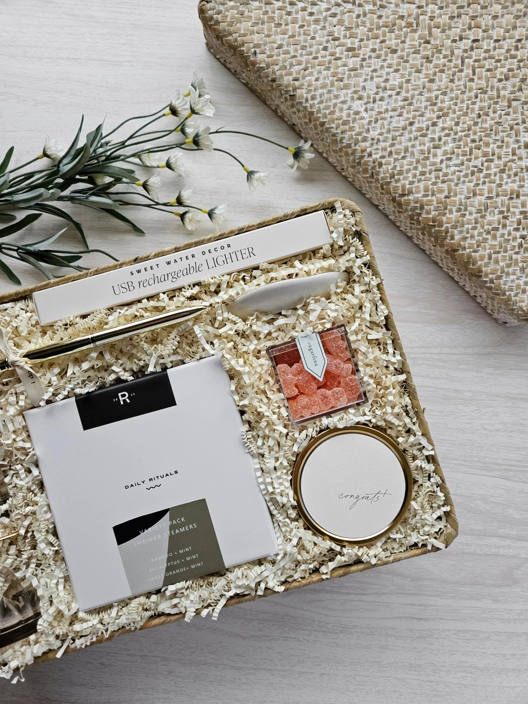 The Vow wedding gift basket with congrats candle, champagne gummies, ring dish, shower steamers, USB lighter, and ring pen.