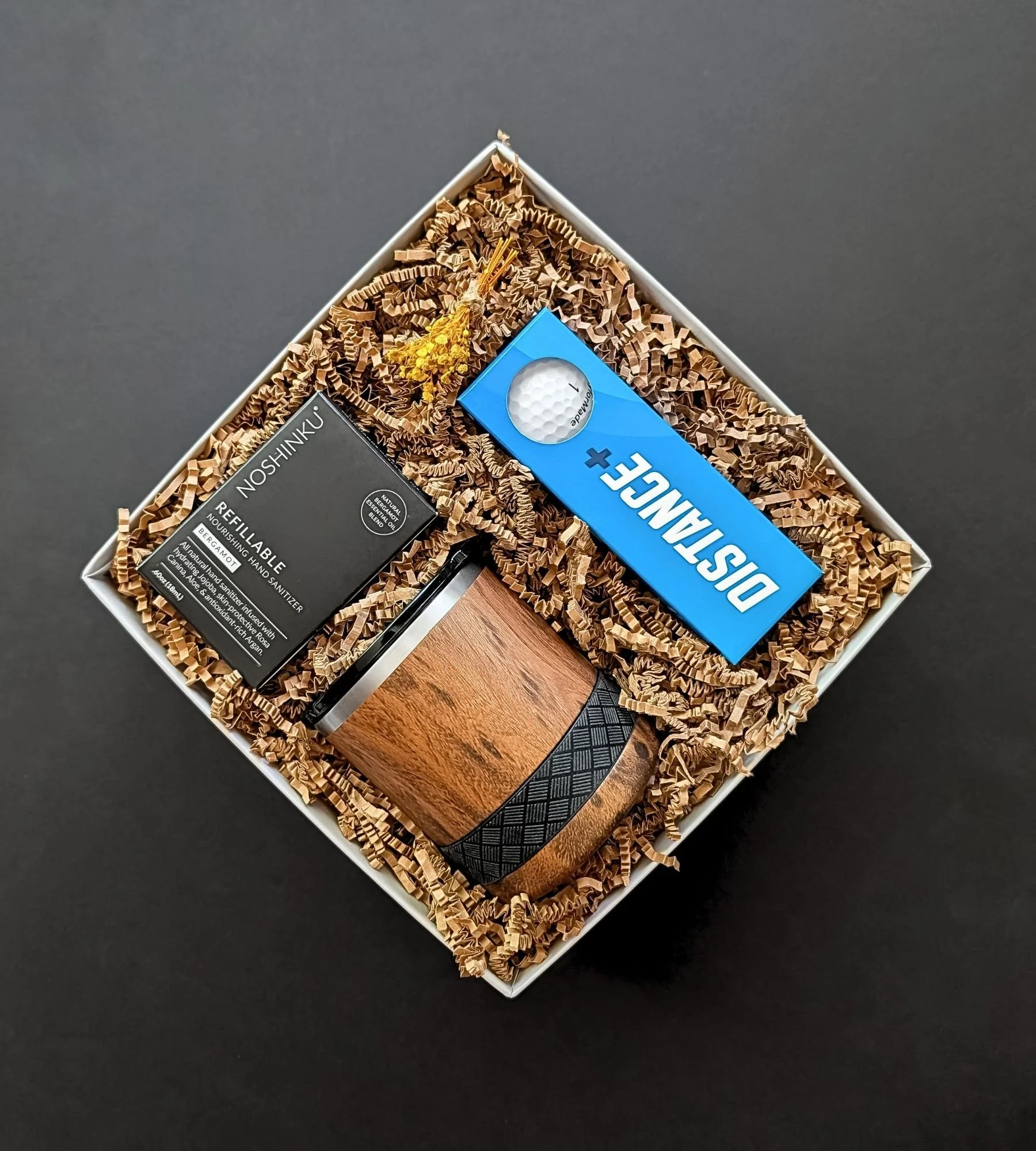 Golf Father’s Day gift box with TaylorMade Distance+ golf balls, Noshinku bergamot sanitizer, and a teakwood rocks tumbler.