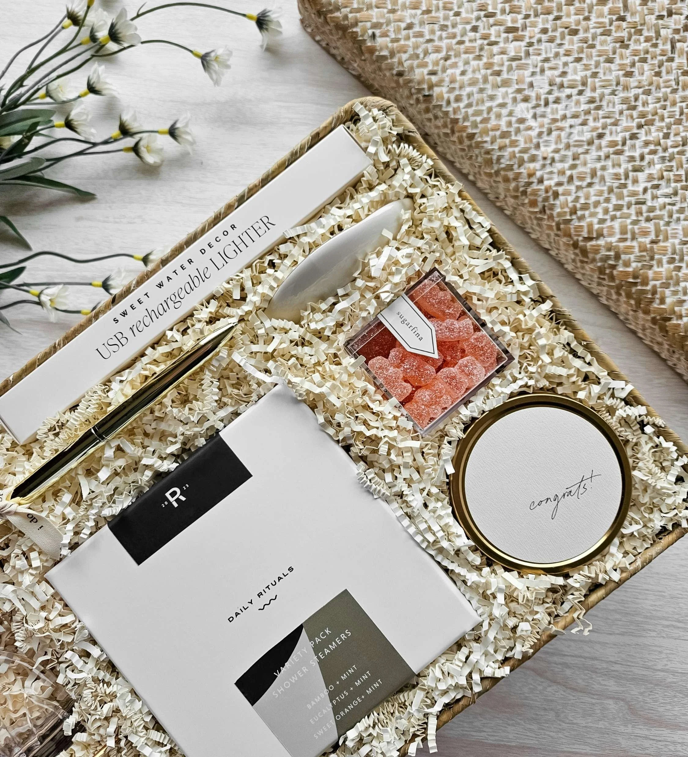 The Vow wedding gift basket with congrats candle, champagne gummies, ring dish, shower steamers, USB lighter, and ring pen.