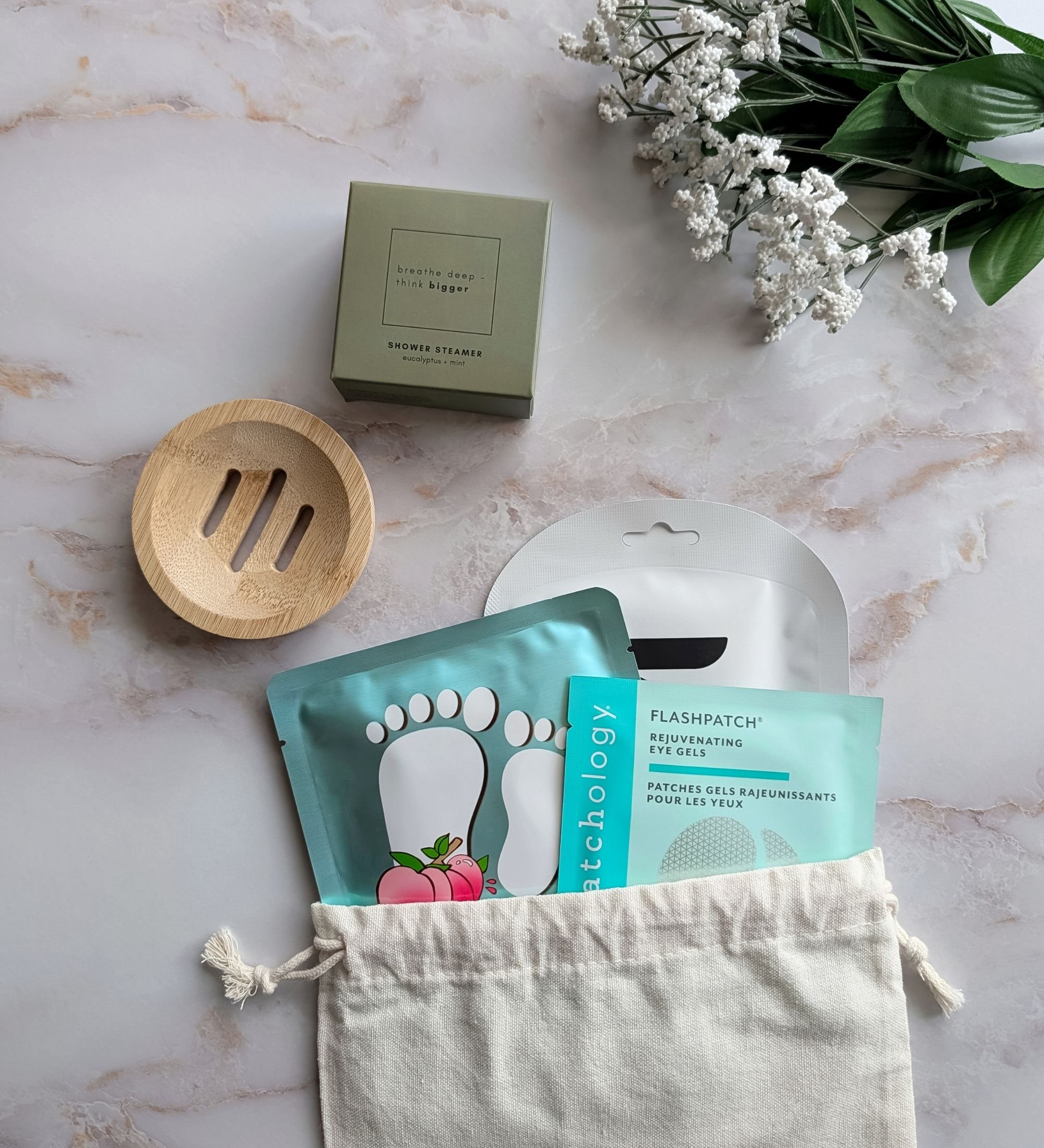 Eco‑friendly “Relax” spa gift bag filled with a face mask, eye gels, foot mask, eucalyptus shower steamer, and bamboo tray.