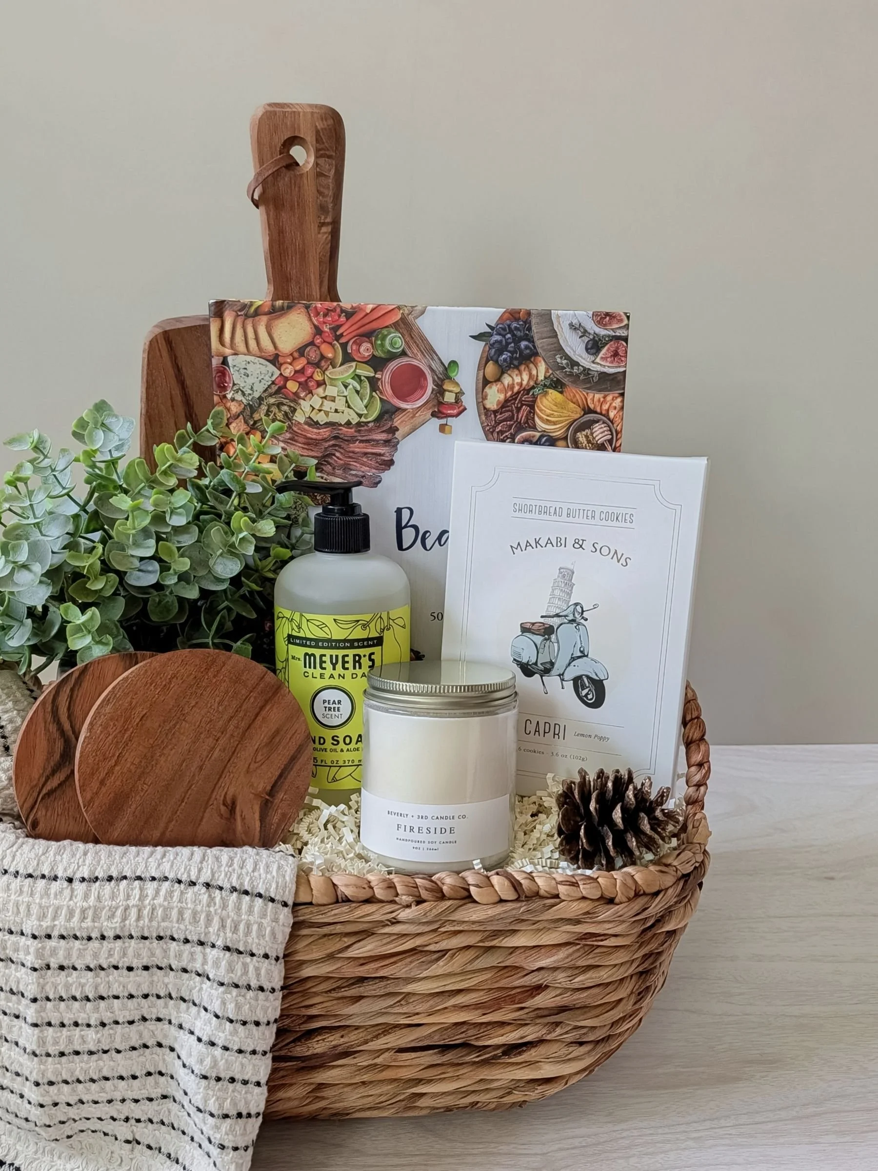 Housewarming gift basket with serving board, candle, hand towel, and minimalist home details designed for housewarmings and client gifting.