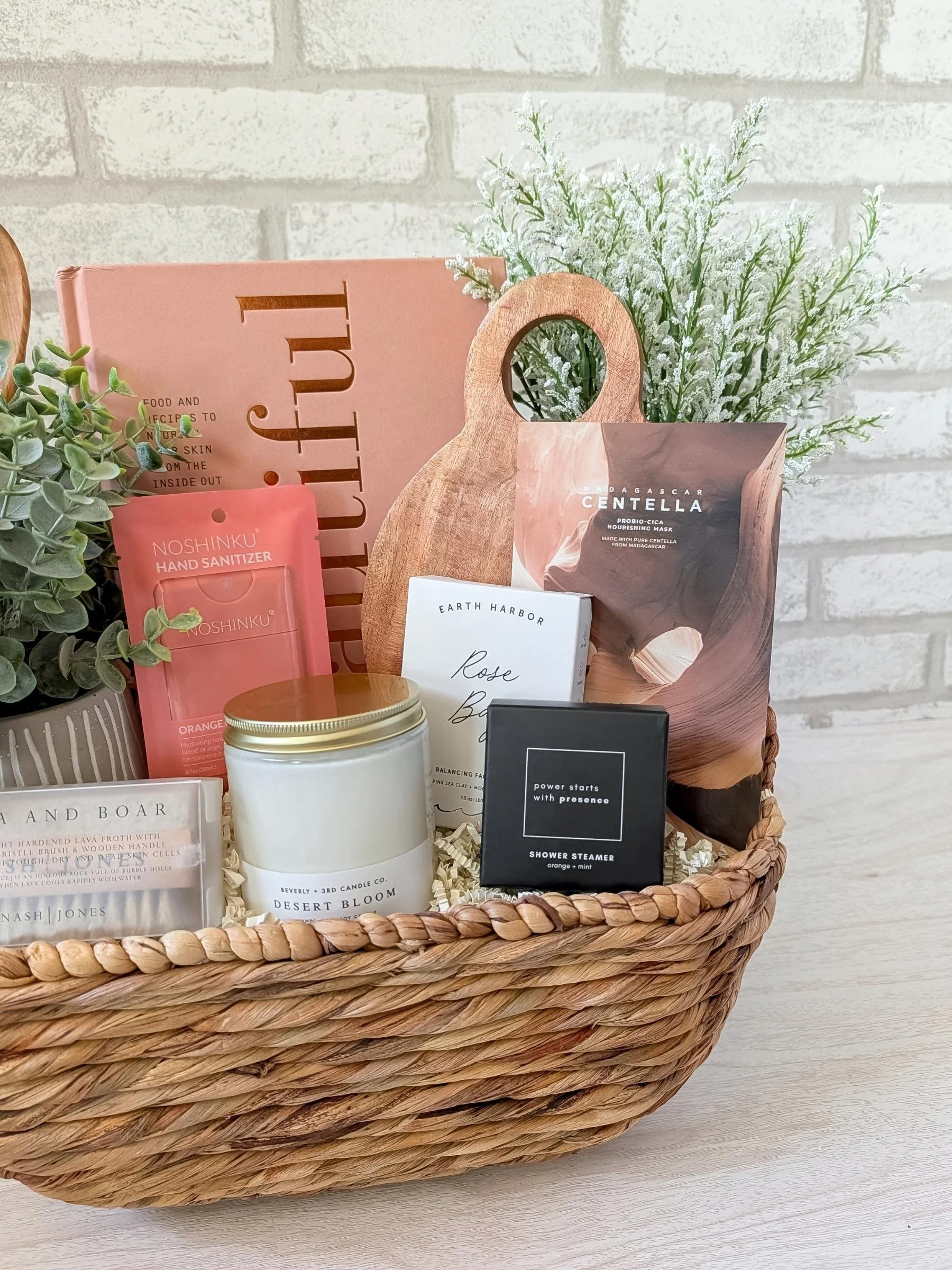Chic Mother’s Day gift basket with cookbook, spa essentials, candle, wooden accents, faux greenery, and premium self‑care products.
