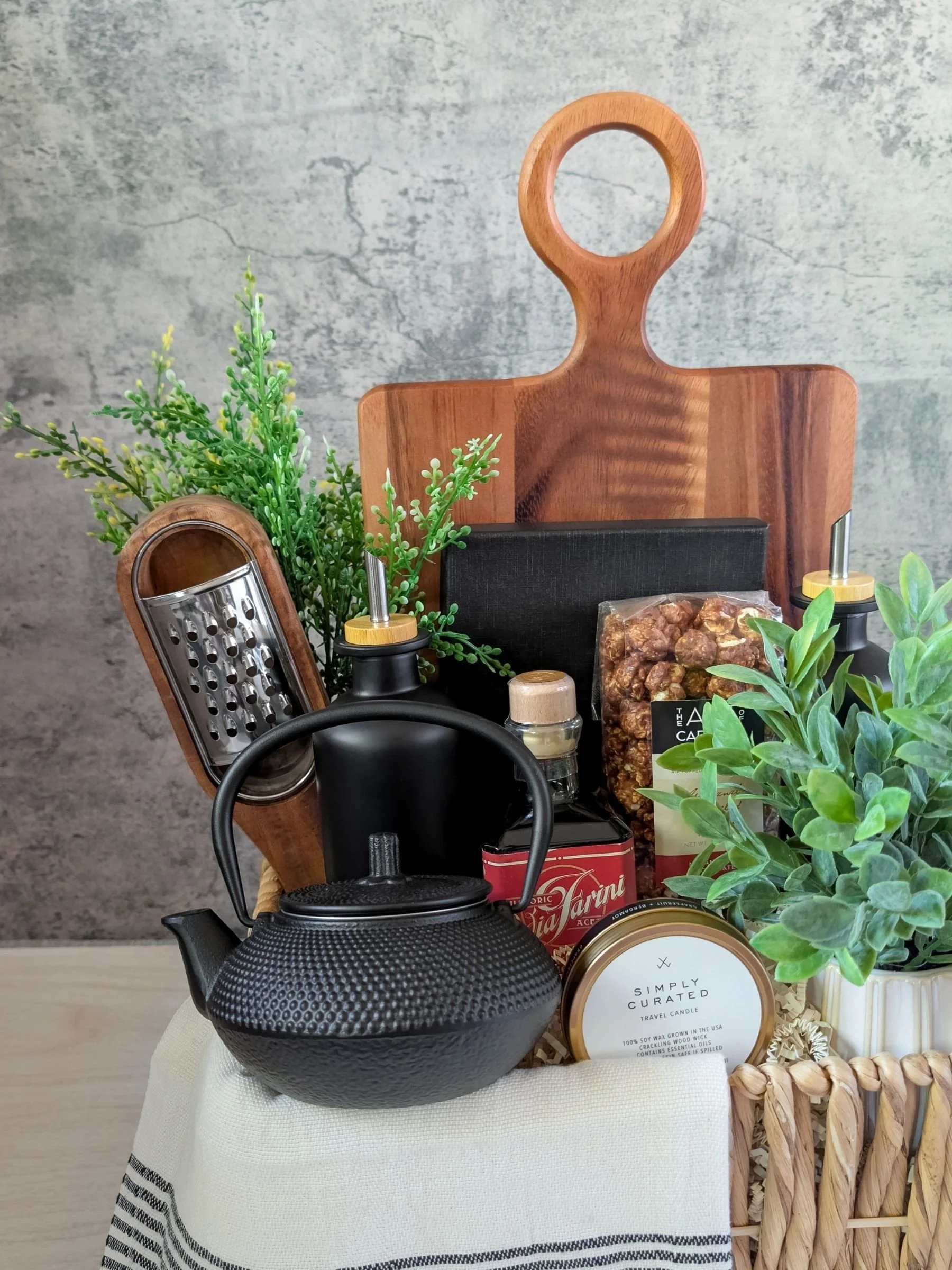 Gourmet modern gift basket featuring a large wood board, charcuterie knives, Turkish hand towel, and artisanal gourmet items.