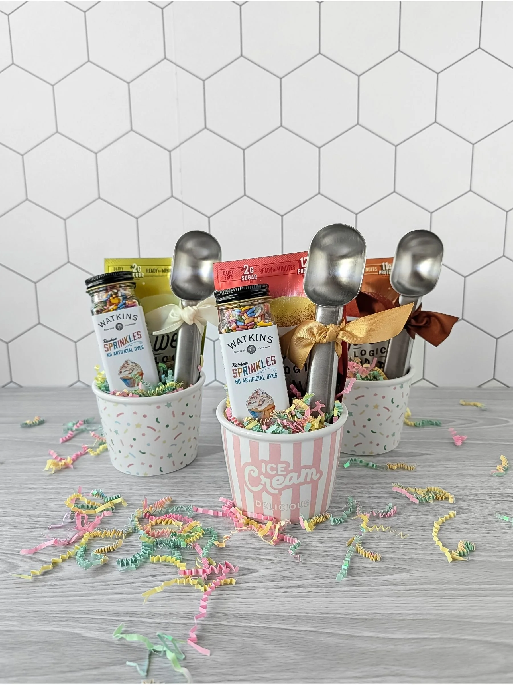 A small ice‑cream‑themed teacher gift with a vintage style ceramic bowl, stainless steel ice cream scoop, colorful sprinkles, and a mug cake mix with colorful crinkle arranged together.