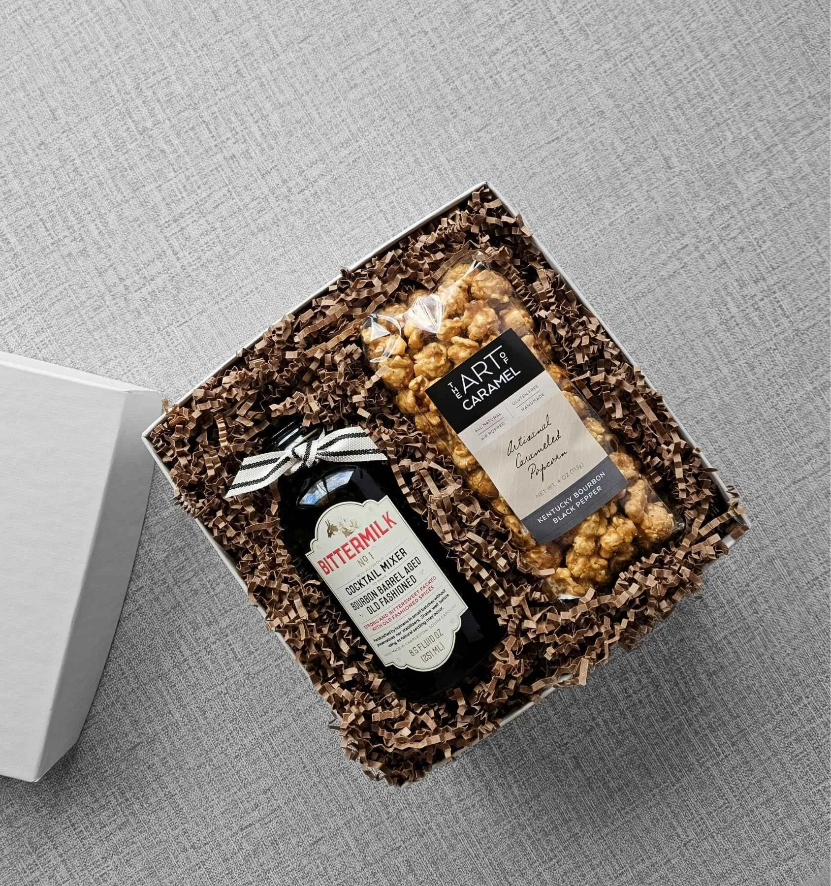 The Bourbon gift box with full‑size cocktail mixer and bourbon‑infused popcorn, a refined gift for clients, colleagues, and celebrations.