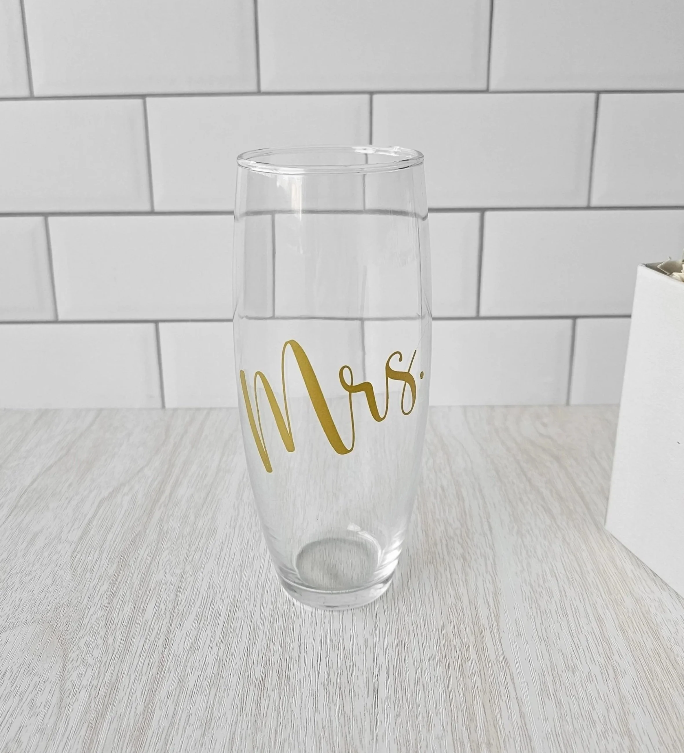 Clear stemless “Mrs.” bridal glass with gold lettering, featured in The Bride gift box as a modern wedding or bridal shower gift.