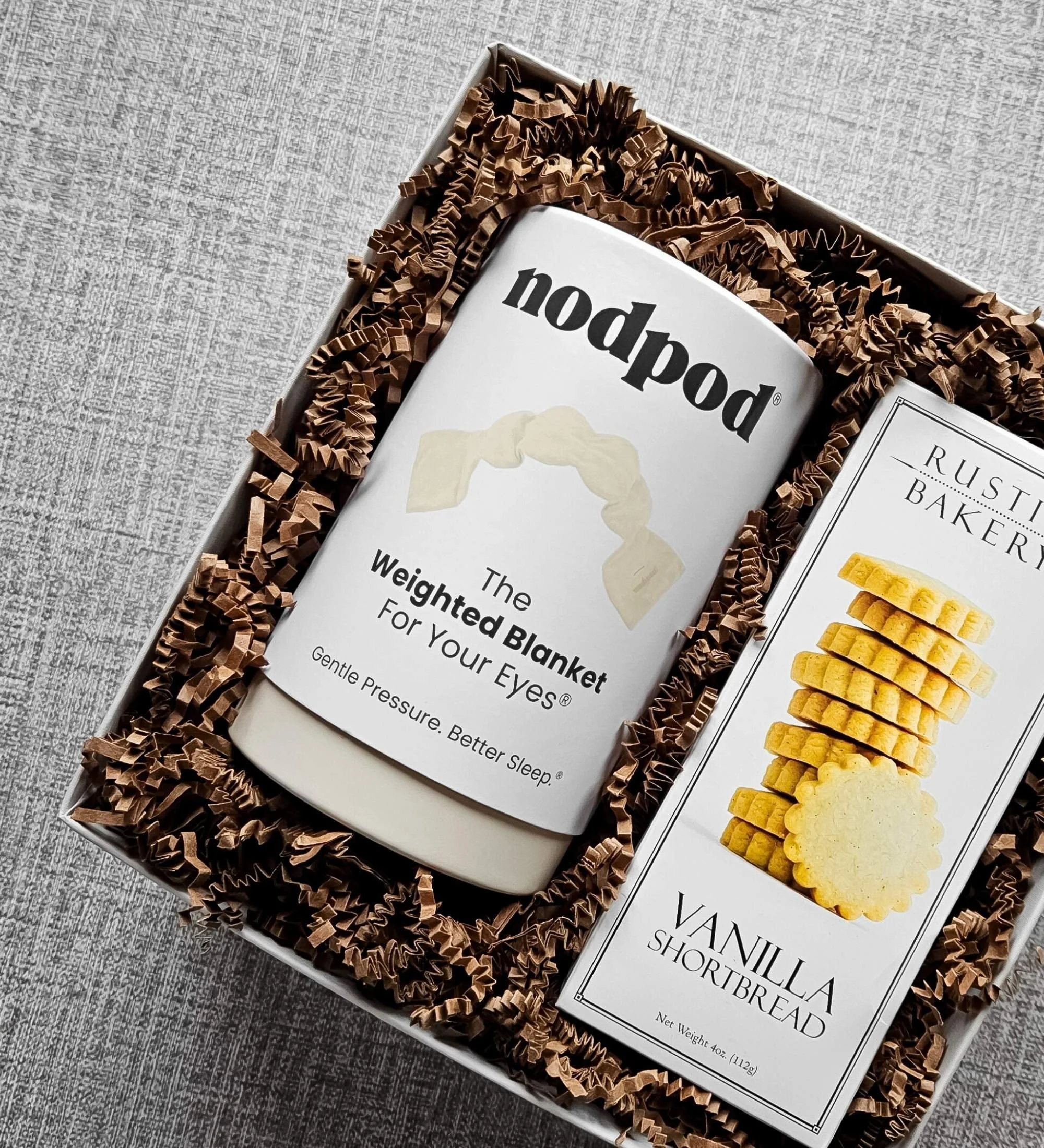 Elegant relaxation gift set with a weighted Nodpod sleep mask and buttery vanilla shortbread cookies, designed for comfort, rest, and meaningful gratitude.