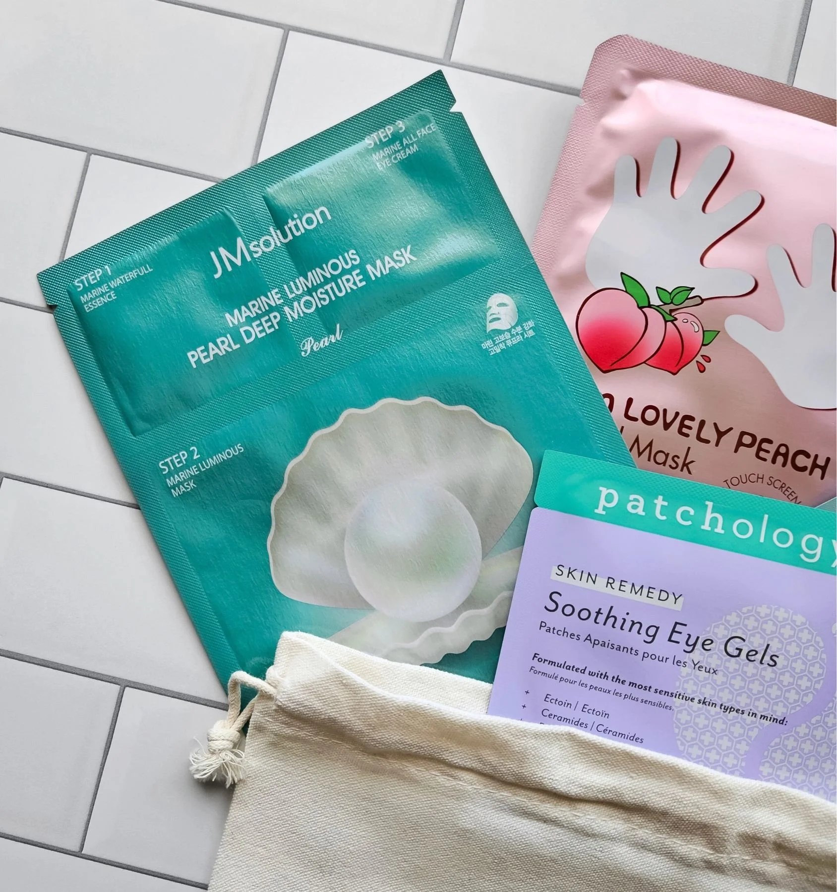 Pampering sheet mask gift bag with Patchology eye gels, TonyMoly peach masks, and a marine pearl mask for glow and relaxation.