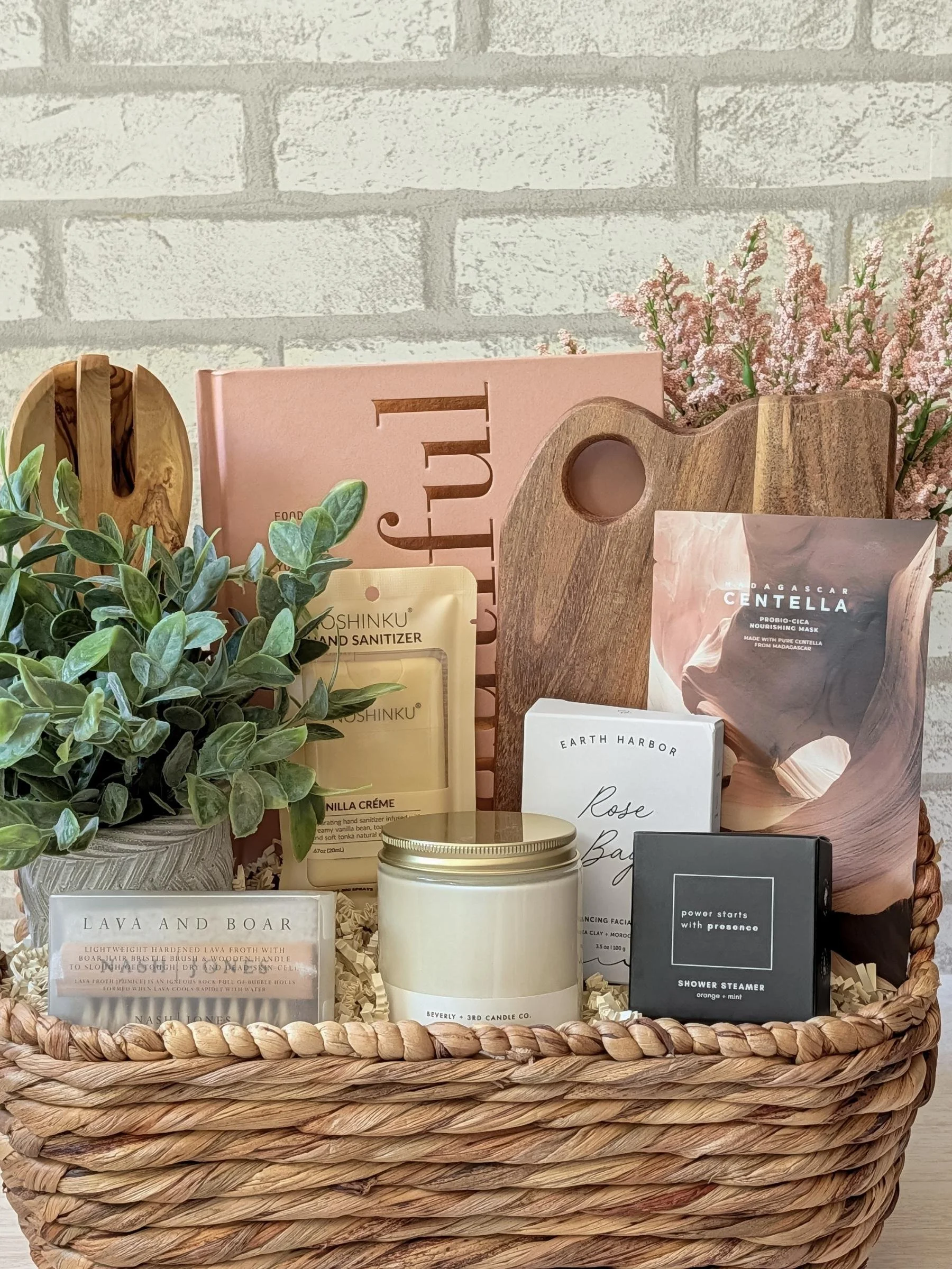 Luxury wellness gift basket featuring Eat Beautiful book, skincare, candle, wooden board, salad spoons, and curated self‑care items.