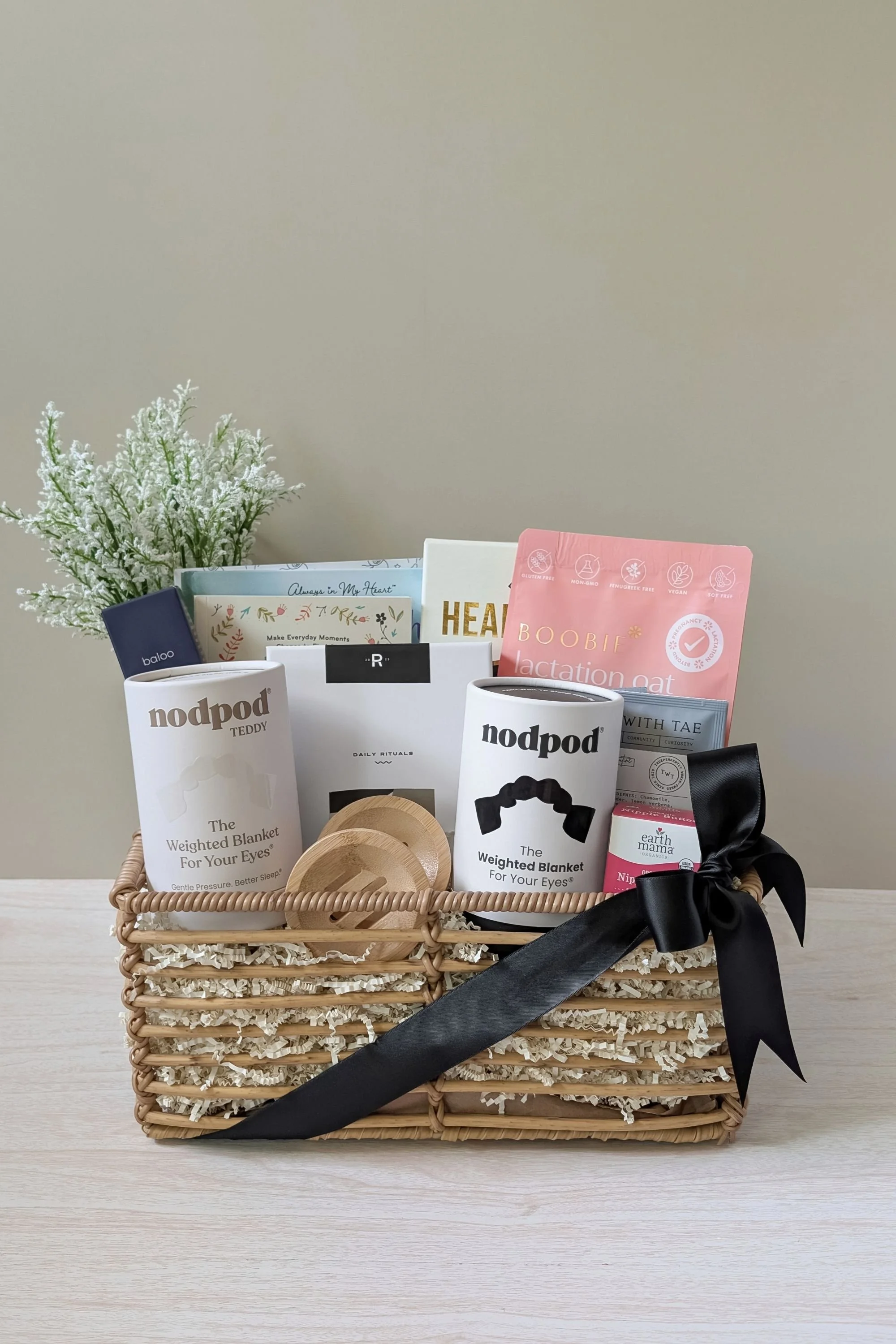 A custom baby shower gift created for first‑time parents, filled with self‑care, wellness, and prenatal essentials. This basket includes books for both mom and dad, a migraine cap, nourishing snacks, clean body care, and comfort items designed to sup