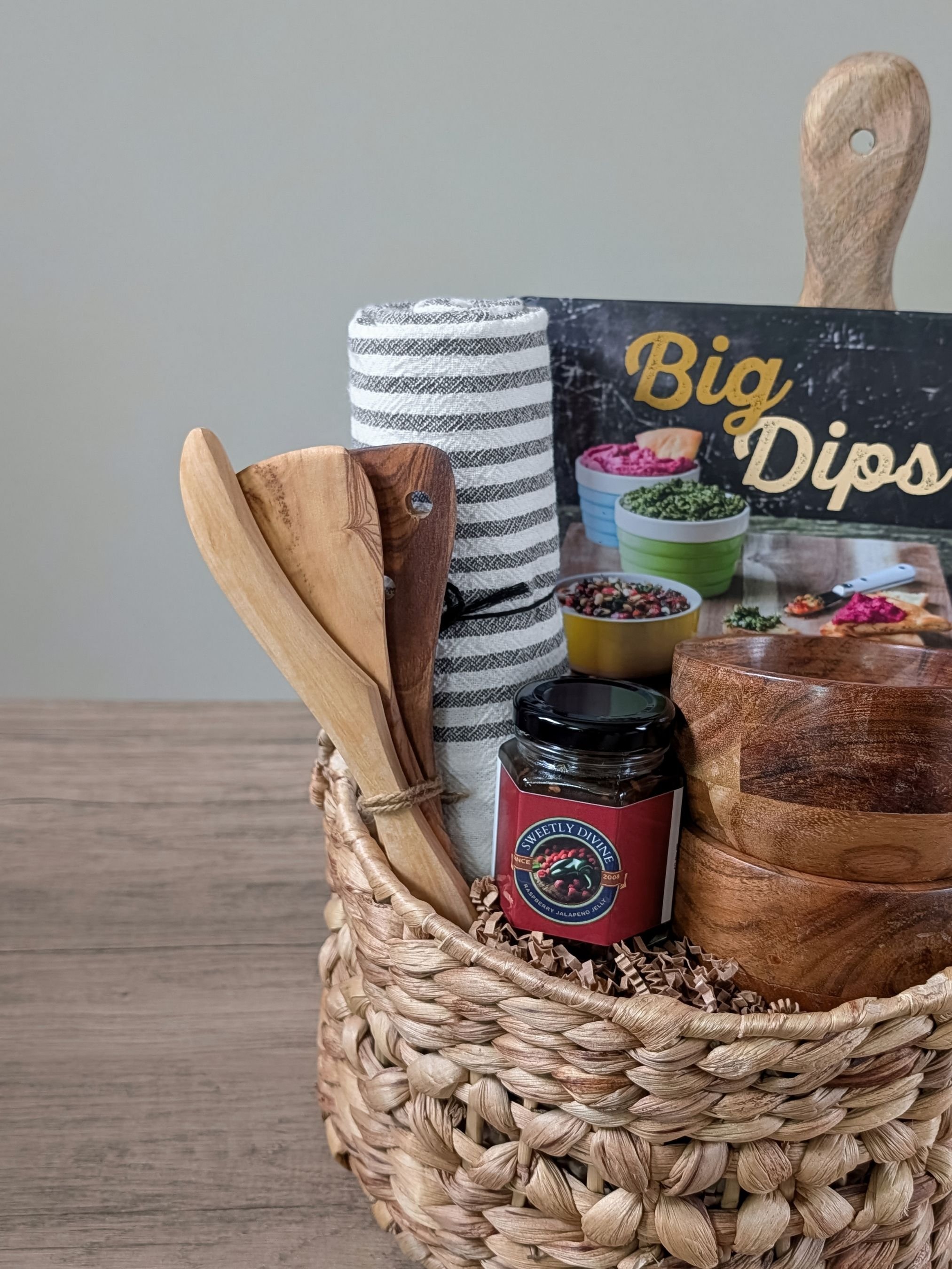 Apéro Bites essentials featuring the Dips book, striped towel, olive wood trio, and cranberry jalapeño jelly.